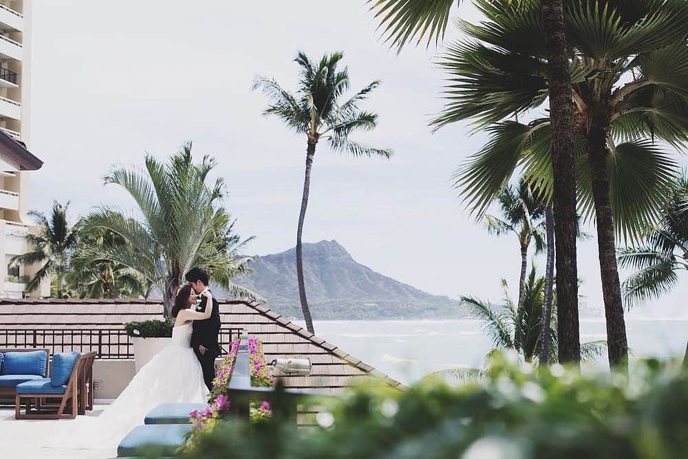 25ans Wedding 公式 Bridesのインスタグラム：「今日も、ハワイで挙式したKayoさんのフォトをリポスト🌴 ヤシの木に広い海、ダイヤモンドヘッドなどハワイらしさ満点の1枚です。自然に祝福されながら、寄り添うふたりが素敵💓」
