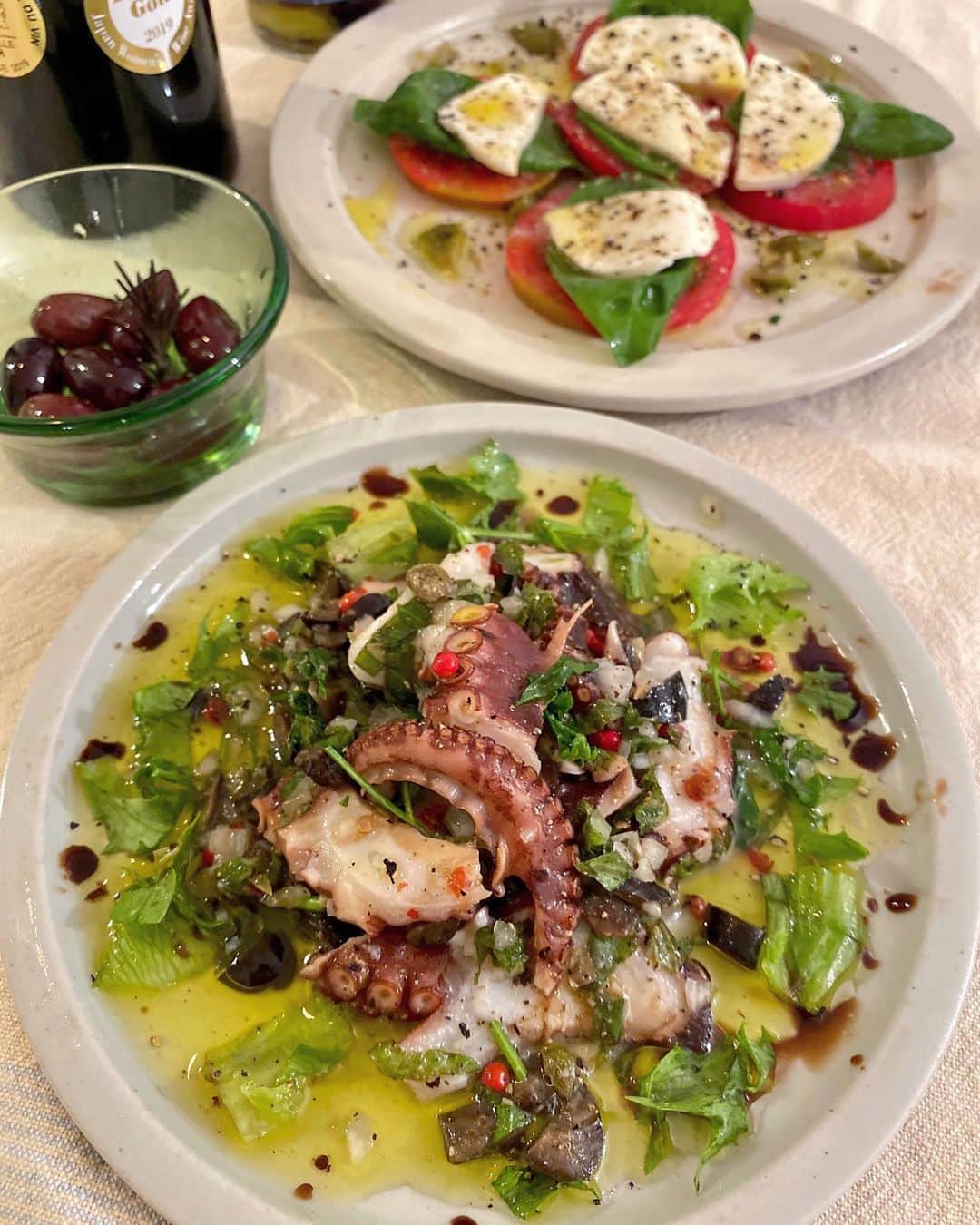 のインスタグラム：「🐙🌿🍋 いろんなお国柄の料理好きだけど育ててるバジルの匂い嗅いだら無性に食べたくなって地ダコで作ってみた。(匂いの記憶へのアクセス精度って半端なく正確)。 こんな風に思い立った時ハーブ摘んで使えるのが嬉しい。  それとこのオリーブのマリネは今まで食べた中で一番の衝撃の美味しさで以前ホテルのシェフさんがお持ち帰りに用意してくれた逸品。  #herbs #タコのマリネ #カプレーゼ #イタリアン #うちごはん #自炊 #クボタ食堂 #小坪 #牛窓」