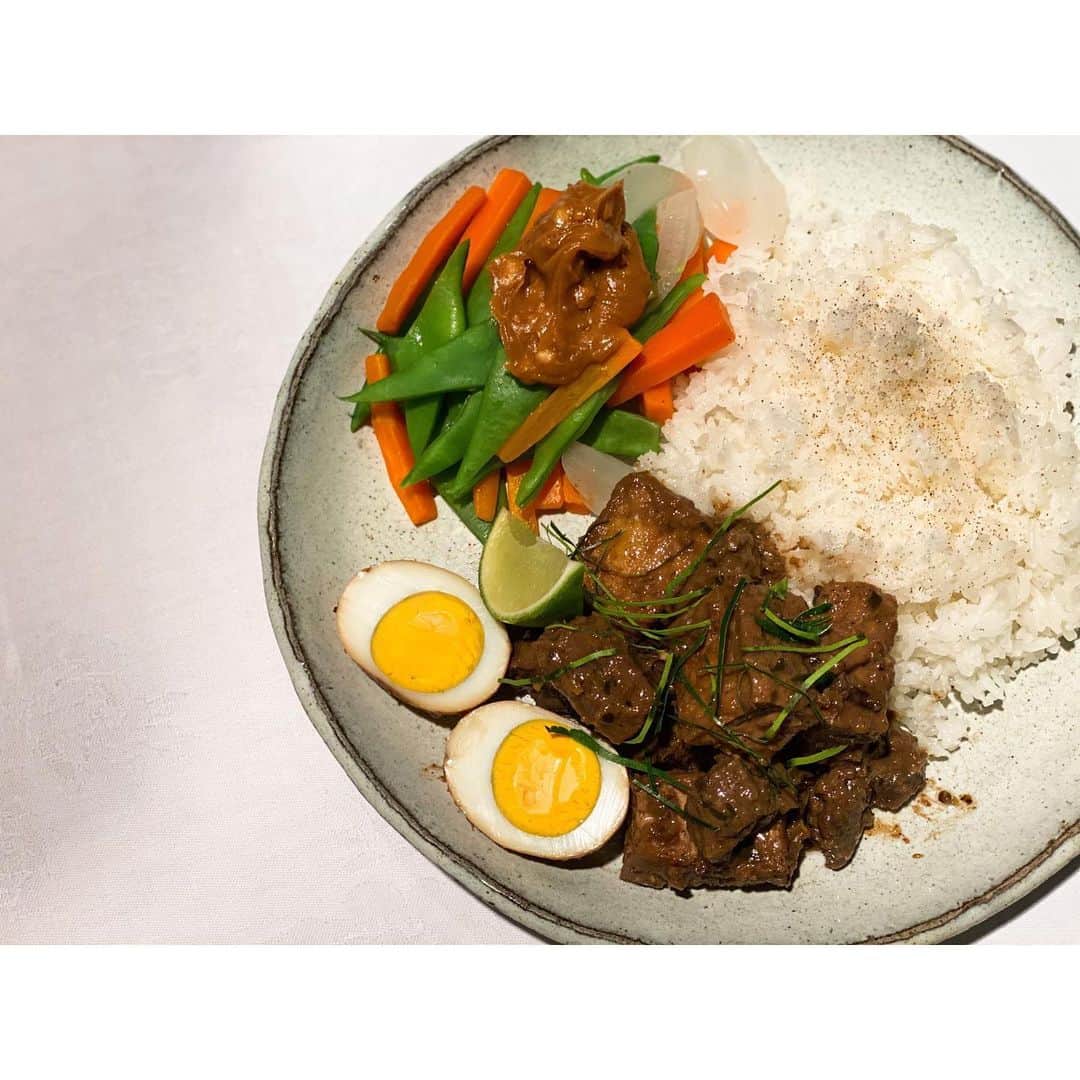 内田朝陽さんのインスタグラム写真 - (内田朝陽Instagram)「牛のルンダンとガドガド  季節に合うインドネシア料理を作りました。 ココナッツとスパイスで煮込んだノスタルジー夏物料理。  ピーナッツバターと酢とナムプラーで作ったピーナッツのソースで温野菜食べるとおいし。  以下、栄養士　@mikichon_chon からのコメント  ルンダンは、塊肉をココナッツミルクとスパイスで長時間煮込んだ肉料理です。 牛すね肉を使うことで、高たんぱく低脂肪でコレステロールも少ないルンダンに。牛すね肉は、コラーゲン、エラスチンなどのタンパクが豊富なので、肌のハリだけでなく血管や肺など体全体の弾力・伸縮にも関与し健康的に◎  ココナッツオイルやミルクは、ラウリル酸などの中鎖脂肪酸が多く、エネルギー源として速やかに利用されやすい(体内に蓄えにくい)です。腹持ちもいいので、体を鍛えている方にオススメ。 ガドガドのピーナッツと相性が良く、ビタミンEの効果がプラスされ細胞の老化を防ぎます。  にんじん、インゲン、玉ねぎなどの彩り野菜でビタミン類やミネラルを追加するとバランスの良いワンプレートになりますね！  #ルンダン　#randang #indonesia #ココナッツオイル #ココナッツミルク　#スパイス　#カレー」6月7日 22時55分 - asahi_uchida
