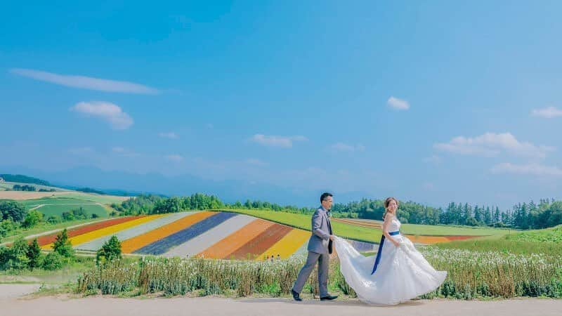のインスタグラム：「鮮やかなお花畑が広がる四季彩の丘は、一度は訪れてほしい絶景スポット🌼🌸﻿ ﻿ ﻿ \\オンライン相談会はじめました//﻿ ご予約はプロフィール欄のホームページリンクから✨﻿ ﻿ 7月から9月の撮影予約も好評受付中です！﻿ ﻿ ﻿ ﻿ #パッチワークの丘  #STUDIOSOLA﻿ #スタジオソラ ﻿ @decollte_weddingphoto @decollte_weddingstyle @d_weddingphoto_jp﻿ #weddingphoto  #instagood #結婚式前撮り #新婚旅行 #チェリフォト #北海道旅行﻿ #富良野 #北海道前撮り#牧場 #ロケーションフォト #tokyo_camera_club #前撮り#東京カメラ部﻿ #weddingdress #prewedding #写真好きな人と繋がりたい #ひまわり畑  #ラベンダー  #ウエディングヘア﻿ #wedding #結婚写真 #前撮り #プレ花嫁#卒花嫁 #日本中のプレ花嫁さんと繋がりたい #結婚式﻿ #結婚式準備」