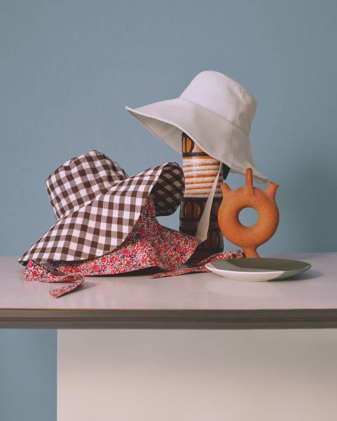 のインスタグラム：「The Fisherman Hats | Maybe the designs of these hats remind you of the ones you wore on those cute photos of you as a child on the beach... and that’s why they’re so cool. The fisherman hat is back stronger than ever: plain in cream tones, printed with flowers or gingham check. Warning: they’re maxi size! Shot by @peterock29  #MangoCollection」