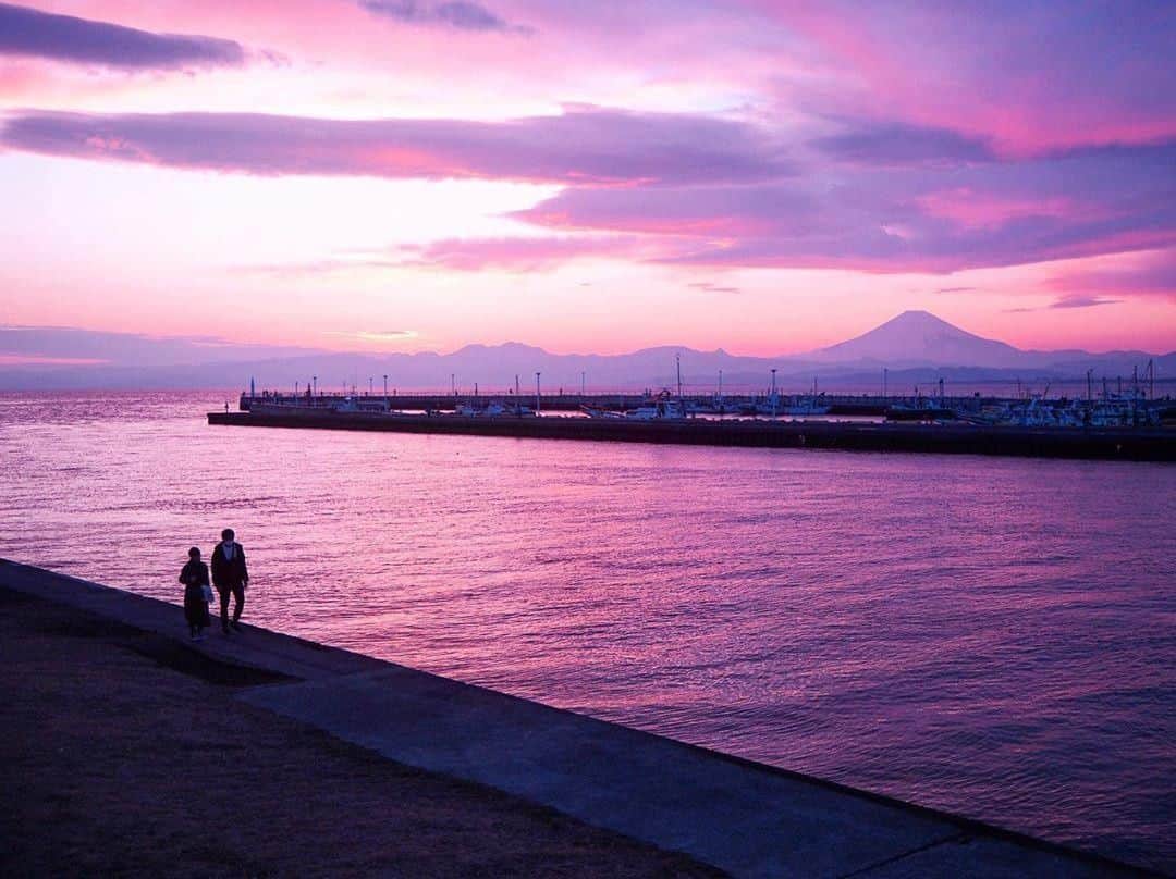 エイチ・アイ・エスのインスタグラム：「日本の写真で虹を作ろう🌈 本日は #日本の紫色のセカイ より紫色のお写真をご紹介💜 . 『江ノ島海岸』 イルミネーションをしていた夜の江ノ島を楽しもうと、夕暮れ時に江ノ島へ向かっている時の一枚です♪ . 📍 神奈川県「江ノ島海岸」 📷 @akane__818 < Thank you! . . ―― 日本全国の写真で虹を作ろう ―― 色とりどりの日本の写真で全国を7色で彩りませんか？ 「#日本の〇色のセカイ」 次の7色から色を選んでを投稿してね☟ 白・赤・オレンジ・黄・緑・青・紫 集まったお写真はHISの各メディアやSNSでご紹介します😃 . 見たい景色を探して、“おうちで”世界を楽しもう♪ #次はどこに行こうかな . . #江ノ島 #鎌倉 #夕焼け #マジックアワー #富士山 #enoshima #kamakura #sunset #おうち旅行 #写真好きな人と繋がりたい #ファインダー越しの私の世界 #誰かに見せたい風景 #絶景 #旅行 #世界遺産 #死ぬまでに行きたい世界の絶景 #instatravel #instapassport #instatraveling #travelgram #lovetravel #traveljapan #lovers_nippon #japan #photooftheday #japantrip #japantravel」