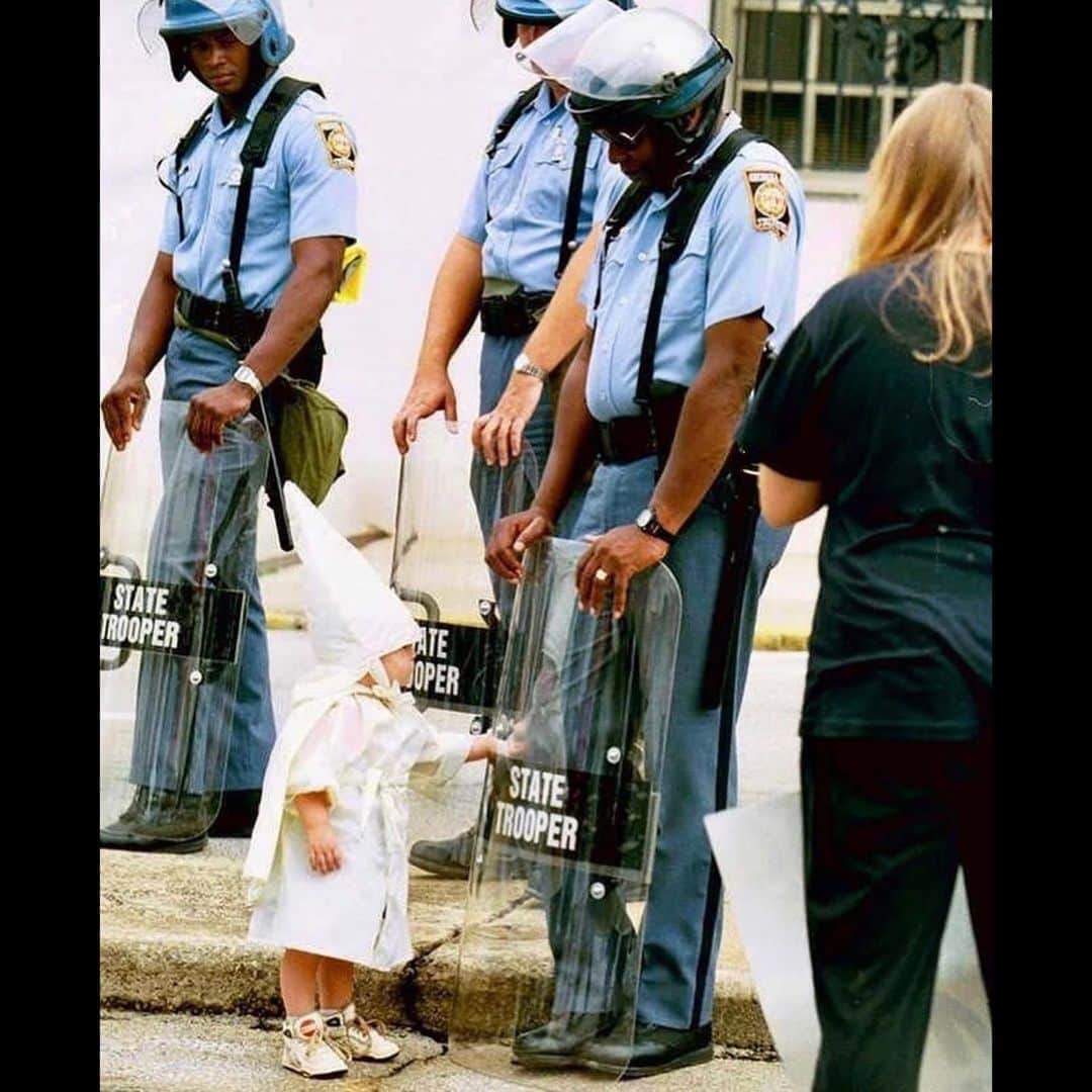 ティモシー・サイクスのインスタグラム：「Repost from @karmagawa This heartbreaking photo from a 1992 KKK rally shows a Klan-robed child touching the riot shield of an African-American state trooper — despite being born with love in his heart, this little boy was taught to hate by his parents. Swipe left to see video of Jane Elliott, a teacher and anti-racism activist, explaining that nobody is born with a racist gene, children are taught by family members who pass on their hate AND THIS MUST STOP NOW! If racism can be learned then it can be unlearned too, so let’s work together and educate the youth of the world by sharing this important message with our followers and tagging people, celebrities, influencers and news media who need to see it too and encouraging them to share with their followers too as we MUST make this go viral so that EVERYONE becomes aware that #blacklivesmatter and that ALL human beings are equal no matter what race they are! #blacklivesmatter✊🏽✊🏾✊🏿 #equality #karmagawa」