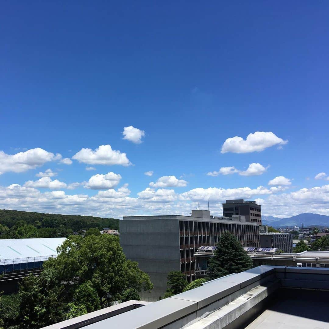 Kumamoto COC+のインスタグラム：「暑いですねえ！工学部1号館と立田山、奥は阿蘇が見えてます。空だけ見ると夏ですが、その前に梅雨入りです。ほどほどに降って欲しいですね。」