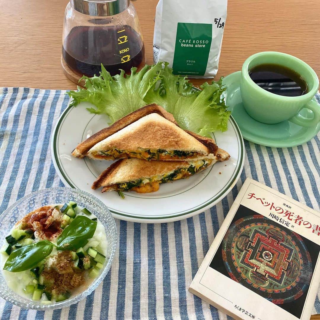 クボタマサヒコのインスタグラム：「🥪🥬🥚🧀 ちょうど今日、ダライ・ラマのアルバム(!)からの先行シングル(!?)がリリースされるという(個人的に)センセーショナルなニュースがありましたね。Apple Musicで聴きましたが普通に良かったです。ダライ・ラマの生誕日7/6にアルバムが出るとの事でかなり楽しみ。  #hotsand #coffee #fireking #kono #クボタ食堂 #caferosso #チベット死者の書 #books #booksandcoffee #ライタ #raita #रायता #インド料理 #spice  大量に育ち続けるイタリアンパセリのオムレツはケチャップじゃなくてタイのチリソースで。ライタはバジルのせ、コーヒー豆は島根のCAFE ROSSOさんのロースト。」