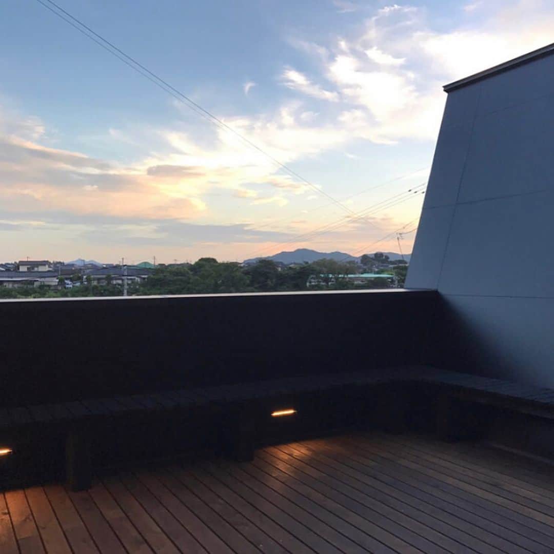 ムクリ［mukuri］さんのインスタグラム写真 - (ムクリ［mukuri］Instagram)「高台にある「宇宙船」。中には空へと続くLDKが待っていた。mio.home__さんのおうちを探索！﻿ ﻿ 家族とベランダでワイワイ楽しみながら食事を取り、﻿ 夕日を眺めながら一杯楽しむ休日。﻿ それが叶う @mio.home__ さんのおうち。﻿ ﻿ 玄関へと続く階段も宇宙船の乗り込む様子さながら。﻿ リビングからの景色は圧巻です。﻿ ﻿ 外観はアルポリックという素材で﻿ 振動減衰性や遮音性にも優れたモノ。﻿ お住まいが大きな地震のあった地域で、﻿ 外観のコダワリと比例して、耐震性も考えたつくり。﻿ ﻿ ウォルナットとマットブラックで統一したインテリアは﻿ 大人な落ち着きを感じます。﻿ ﻿ キッチンはトーヨーキッチンと、﻿ 背面収納は造作。ちょっとした工夫も隠されています。﻿ ﻿ ぜひご覧ください。﻿ ﻿ ▶︎ご紹介した記事﻿ https://mukuri.themedia.jp/posts/4095108﻿ サイト下部＞トーヨーキッチンのカテゴリにあります﻿ ﻿ ﻿ ﻿ ﻿ #マイホーム #注文住宅 #2階リビング #新築 #家づくり #キッチン #kitchen  #トーヨーキッチン #アイランドキッチン #キッチン収納 #カゲナウ #マイホーム計画 #住まい #建築家とつくる家 #myhome #インテリア #interior #ウォルナット #無垢 #造作 #architect #マイホーム計画中の人と繋がりたい #玄関 #テラス #ウッドデッキ #暮らしを楽しむ #くらしの編集 #ムクリ」6月11日 12時03分 - mukuri_official