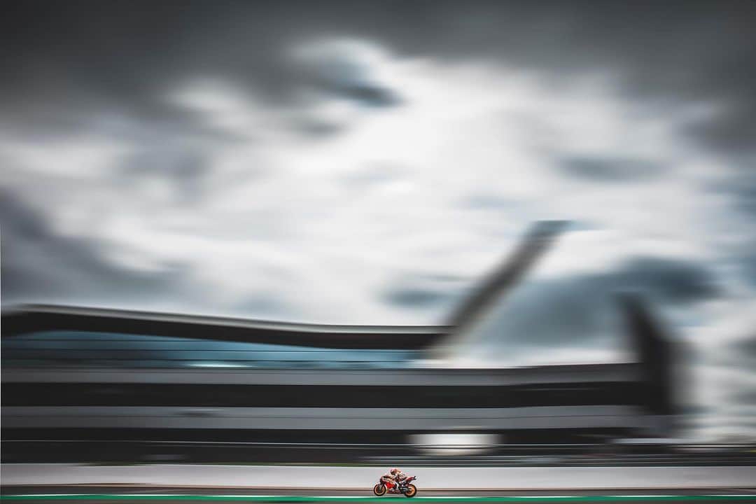 レプソル・ホンダのインスタグラム：「#ThrowbackThursday - Through the Lens - @polarityphoto ⠀⠀⠀⠀⠀⠀⠀⠀⠀ “I love looking at this photo taken at my home Grand Prix in the UK. I wanted to capture something that was unmistakably 'Silverstone' and that incorporated the distinctive wing design of its modern buildings#. Silverstone is a round that I always look forward to because I get to see so many familiar faces, and it feels like a good halfway point for me during the season to take stock of how things are going. And, if i'm honest, it also brings an extra bit of healthy pressure to achieve something special at my home circuit. So, after a bit of scouting around on the Thursday prior to race weekend I found this spot and tried various focal lengths to see what would work; my aim was to keep the whole wing in the frame but without losing focus on the bike. I think it came out pretty well in the end!” 1/50 Sec  F/22  24mm  ISO100」