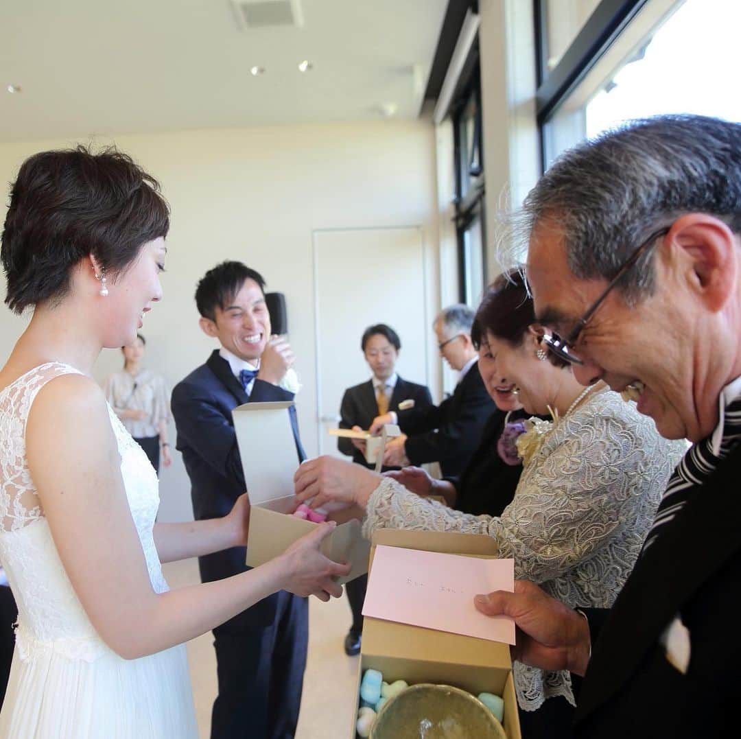 のインスタグラム：「【パーティーレポート】新郎新婦のお二人から両親へ、記念品の贈呈。﻿ 中身は…福井県にある金津創作の森で、お二人が手作りをされたお茶碗！　心のこもったプレゼントにお父様、お母様はとっても嬉しそうな笑顔を浮かべていらっしゃいました。﻿ ﻿ LOCATION : UMI no RUSTICWEDDING﻿ PARTY SPACE : LAGO BIANCO﻿ GUEST : 46﻿ SEASON : SPRING﻿ ﻿ M&Uの公式サイトでは、挙式・披露会陰会場のご紹介やパーティーレポート、最新の情報などをご確認いただけます。﻿ ﻿ プロフィール( @mandu_wedding )内にあるURLよりご確認ください。﻿ ﻿ *・。*・。*・。*・。*・。*・。*・。﻿ ﻿ 【苔の里・木場潟を巡る♪ 杜と湖のラスティックウエディング見学会】﻿ ﻿ 南加賀の大自然を舞台とする“杜と湖のラスティックウエディング”。﻿ その舞台となる苔の里・木場潟の見学ツアーです。﻿ 実際のロケーションを体感してお二人のイメージを膨らませてください！﻿ ﻿ ○開催日／土日祝の11:00〜15:00（完全予約制）﻿ ○お問い合わせ・お申し込み／プロフィール内のリンクより公式サイトにお進みください。﻿ ﻿ *・。*・。*・。*・。*・。*・。*・。﻿ ﻿ 【M&U WEDDING の結婚式】﻿ ﻿ 100年経っても変わらないこの景色。﻿ 訪れるたび、幸せの記憶がよみがえる。﻿ ﻿ 石川県小松市。ここにある自然環境を最大限に活かした、シンプルでナチュラルな結婚式、『ラスティックウエディング』﻿ ﻿ ラスティックとは、「素朴」や「温かみ」という意味があります。﻿ 自然に囲まれて、気持ちのよい日差しを浴びながら、飾り過ぎない素の美しい世界で、大切なゲストとかけがえのない時間を過ごす。まるで映画のワンシーンのようなウエディングです。﻿ ﻿ *・。*・。*・。*・。*・。*・。*﻿ ﻿ ﻿ ﻿ ﻿ ﻿ #両親ギフト﻿ #エムアンドユー花嫁 #パーティーレポート﻿ #杜と湖のラスティックウェディング #エムアンドユー #苔の里 #木場潟公園 #石川 #石川県 #小松市#小松 #金沢市 #金沢 #加賀 #加賀市 #野々市#野々市市 #白山 #白山市 #小松結婚式 #小松市結婚式 #小松結婚式場 #小松市結婚式場  #ラスティックウェディング #リゾートウェディング  #小松カフェ #金沢カフェ #ホテルビナリオKOMATSUセントレ #ラーゴビアンコ」