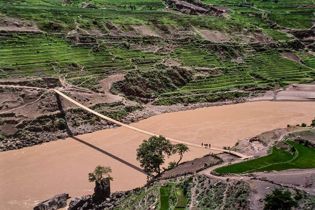 Michael Yamashitaさんのインスタグラム写真 - (Michael YamashitaInstagram)「Untamed River — From a trickle to a torrent, a river runs through it: to Tibetans, it’s known as Dza Chu, or the River of Stones, and to the Chinese it’s the Lancang Jiang, the Turbulent River. As it follows its 2600 mile journey to the sea, the river runs through valleys and gorges plunging ever downwards. In sparsely populated northern Yunnan, the Mekong drops an incredible 15,000 feet, making it a formidable obstacle to cross. Bridges are few and far-between, so the most common method of crossing is by zip line — a single strand of cable strung at a steep angle over the river. Using a sling attached to a pulley, the rider hooks on the cable and with the help of gravity slides down the high wire as if aboard an adventure park ride, suspended several hundred feet over the churning white water to get to the other side. #dzachu #tibetan #lancangjiang #yunnanprovince #mekongriver  A limited number of signed copies of Mike’s out-of-print book “A Journey on the Mother of Waters: Mekong” are available to purchase from our website michaelyamashita.com or the link in our profile.」6月13日 10時21分 - yamashitaphoto