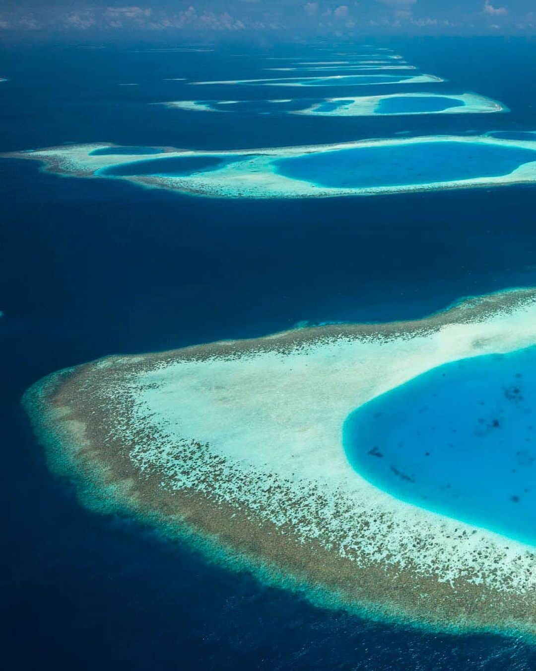 National Geographic Travelさんのインスタグラム写真 - (National Geographic TravelInstagram)「Photos by George Steinmetz @geosteinmetz | Few places are as susceptible to rising sea levels as the island chains of the Maldives. For millennia these atolls in the Indian Ocean have been able to grow coral upward faster than their volcanic foundations have been sinking. But warming seawater has caused widespread coral die-offs, and it is unclear if they can keep up with such a rapidly changing climate. To see more of our world from above, follow @geosteinmetz.」6月13日 5時09分 - natgeotravel