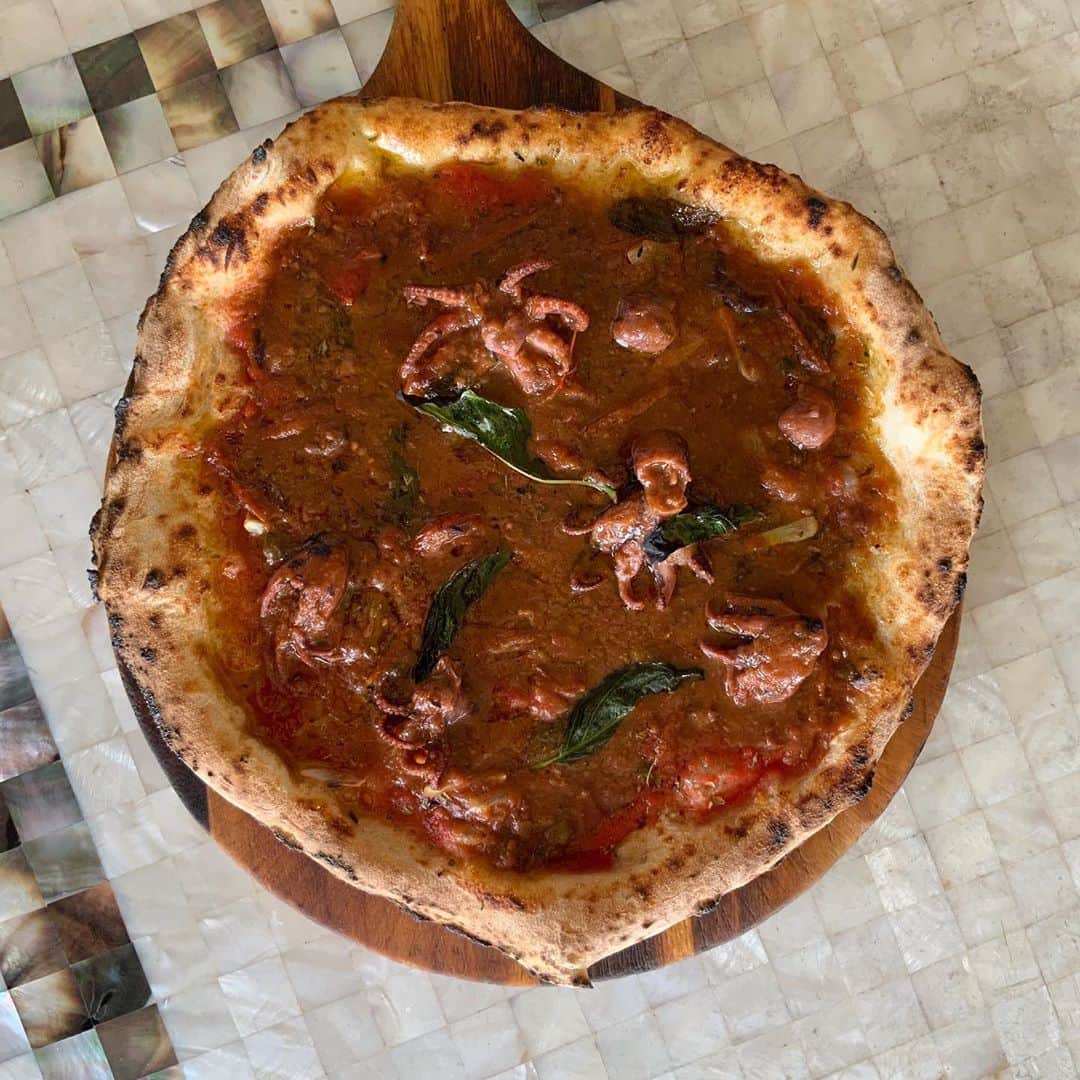 ポジリポのインスタグラム：「今週のピッツァ、パスタのご案内です ・ ・ 〜Weekly Pizza〜 【蛸のルチャーナ風 ピッツァ】  ナポリの漁師たちの街『サンタルチア』 ここの住人『ルチャーナ』 蛸漁師たちのシンプルかつ蛸の魅力を存分に味わう調理法が『ルチャーナ風』 蛸とトマトを煮込む、シンプルかつ究極に旨い食べ方です。 当店ピッツァイオーロJUNいわく『ナポリの夏はこれ』 ・ ・ 〜Weekly Pasta〜 【自家製スーチカーと焦がし枝豆のペストパスタ】  イタリアではよく見られる空豆とペコリーノの組み合わせを 今が旬の野菜枝豆で再現しました。 枝豆をすりつぶしてソースにしたペストをベースに それとは別にしっかり焦げめがつくぐらい焼いた枝豆で 香りを引き立てます。 そこに塩味のスーチカとペコリーノチーズを合わせたパスタ。 枝豆の焼き味と香ばしさが癖になる一皿です ・ ・ ※ランチタイムのチョイスでお選びいただけます」