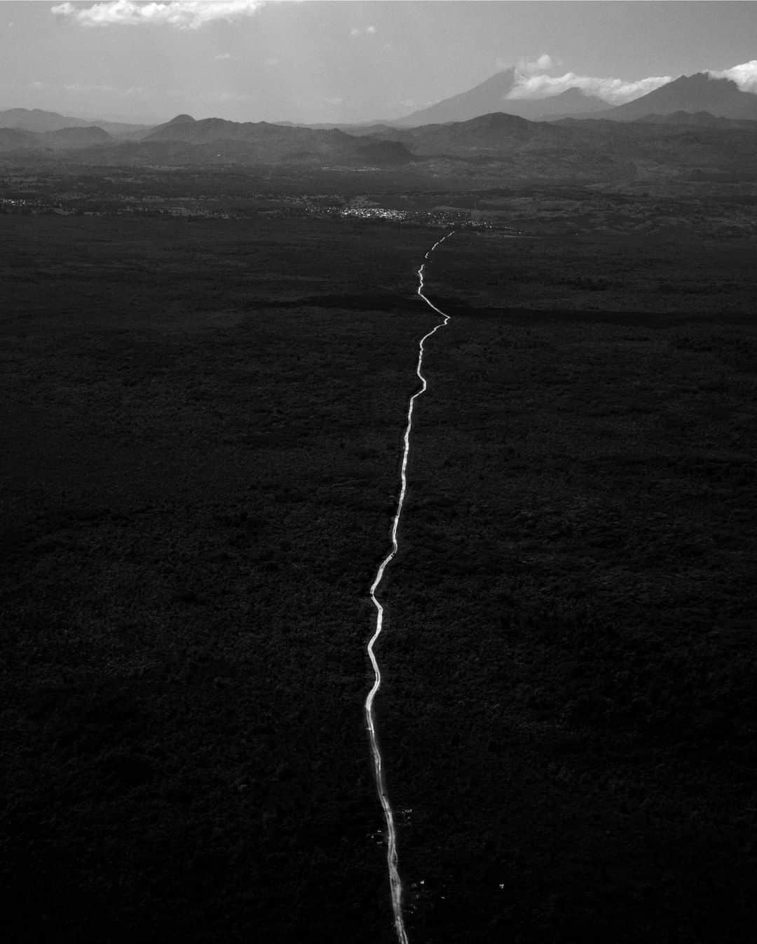 のインスタグラム：「Photo by @michaelchristopherbrown | Aerial of a jungle road leaving Virunga National Park, located in eastern Democratic Republic of the Congo. Among the most protected areas of Africa, Virunga, the continent's first national park, was designated a UNESCO World Heritage site in 1979. It's home to active volcanoes and hundreds of endemic species, including the eastern gorilla and golden monkey. While living in Goma, I spent much time traveling through the lush, remote 3,000-square-mile (8,000 km) area, full of grandeur. Virunga made headlines recently when 12 of its park rangers were killed while protecting people and animals in the park, ever at the mercy of poachers, militias, and others looking to take advantage of park resources.」