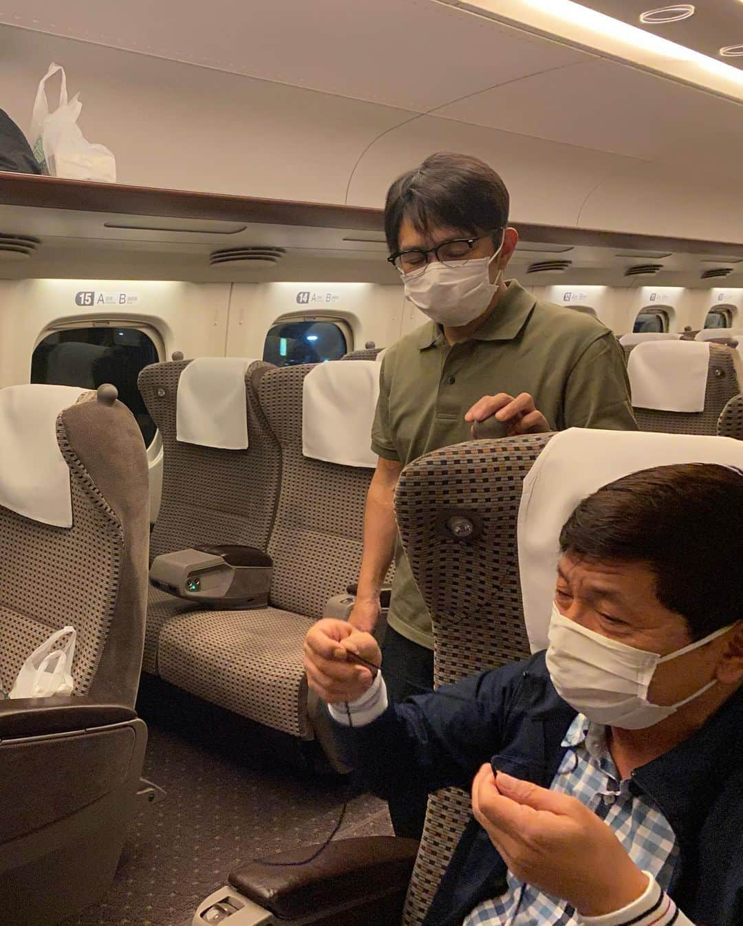 井上聡さんのインスタグラム写真 - (井上聡Instagram)「久しぶりの大阪にて明石家電視台の収録再開しました。帰りの新幹線で我らが神は相変わらず松尾伴内さんをお相手に話し続けておられます。今回もその新幹線の光景を少しだけお伝えします。  #何やら神は鬼滅の刃の手拭いを使って手作りマスクを作り始められたご様子です。 #「俺はねずこな！」と言って、神はとても器用な手つきでねずこが描かれた手拭いをたたみ込みあっという間にマクスを完成させてしまわれたご様子です #そして伴内さんに「松っちゃんは炭治郎な！」と、もうひとつ持っていた炭治郎の手拭いをさりげなく渡しておられました #突然のサプライズに伴内さんは「おお！たんじろう！ありがとうございます！」とすぐさま有難くいただいたのですが、ものすごい小さな声で「たんじろう？たんじろうってなんだろう？」と僕に聞いてきます #炭治郎が何なのか知らないまま作り始めたのですが不器用なのか10分経ってもまだ序盤です。 #いい加減見かねた神と、剛さんまで合流してみんなの協力のもとようやく完成出来ました！ #その後はお二人仲良くその手作りマスクをつけてNetflixの話をされておられます #松尾伴内さん #中川家剛さん #おじさん達が力を合わせて手作りマスク #伴内さんは完成したマスクの炭治郎を見ても無反応だった #明石家電視台 #明石家さんまさん #如何なる状況でも楽しくできる人」6月15日 22時07分 - _ino__