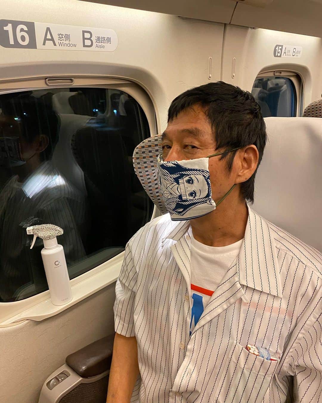井上聡のインスタグラム：「久しぶりの大阪にて明石家電視台の収録再開しました。帰りの新幹線で我らが神は相変わらず松尾伴内さんをお相手に話し続けておられます。今回もその新幹線の光景を少しだけお伝えします。  #何やら神は鬼滅の刃の手拭いを使って手作りマスクを作り始められたご様子です。 #「俺はねずこな！」と言って、神はとても器用な手つきでねずこが描かれた手拭いをたたみ込みあっという間にマクスを完成させてしまわれたご様子です #そして伴内さんに「松っちゃんは炭治郎な！」と、もうひとつ持っていた炭治郎の手拭いをさりげなく渡しておられました #突然のサプライズに伴内さんは「おお！たんじろう！ありがとうございます！」とすぐさま有難くいただいたのですが、ものすごい小さな声で「たんじろう？たんじろうってなんだろう？」と僕に聞いてきます #炭治郎が何なのか知らないまま作り始めたのですが不器用なのか10分経ってもまだ序盤です。 #いい加減見かねた神と、剛さんまで合流してみんなの協力のもとようやく完成出来ました！ #その後はお二人仲良くその手作りマスクをつけてNetflixの話をされておられます #松尾伴内さん #中川家剛さん #おじさん達が力を合わせて手作りマスク #伴内さんは完成したマスクの炭治郎を見ても無反応だった #明石家電視台 #明石家さんまさん #如何なる状況でも楽しくできる人」