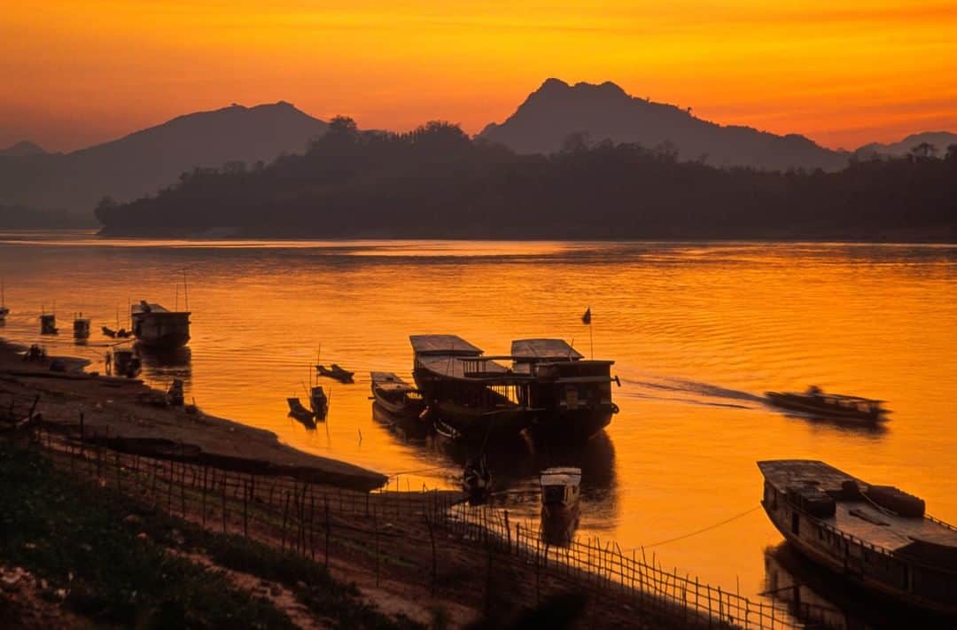 のインスタグラム：「Photo by Michael Yamashita @yamashitaphoto | Troubled waters: The Mekong River is in crisis, at its lowest level since record-keeping began. A drought in the lower basin countries of Thailand, Cambodia, and Vietnam, coupled with new dams built upstream in Laos and China, has exacerbated a perilous water shortage largely caused by climate change. With the drastically reduced water levels affecting food crops grown on its banks, and fish stocks that have fallen sharply, many of the 60 million people who depend on it have been forced to give up their former livelihoods as farmers and fishermen. Here’s what the healthy banks of Luang Prabang looked like back in the 90s, when I traveled the river from its source on the Tibetan Plateau to its mouth in Vietnam’s Mekong Delta. Recent news sources are reporting that this section is currently unnavigable.  #LuangPrabang #Laos #MekongRiver」