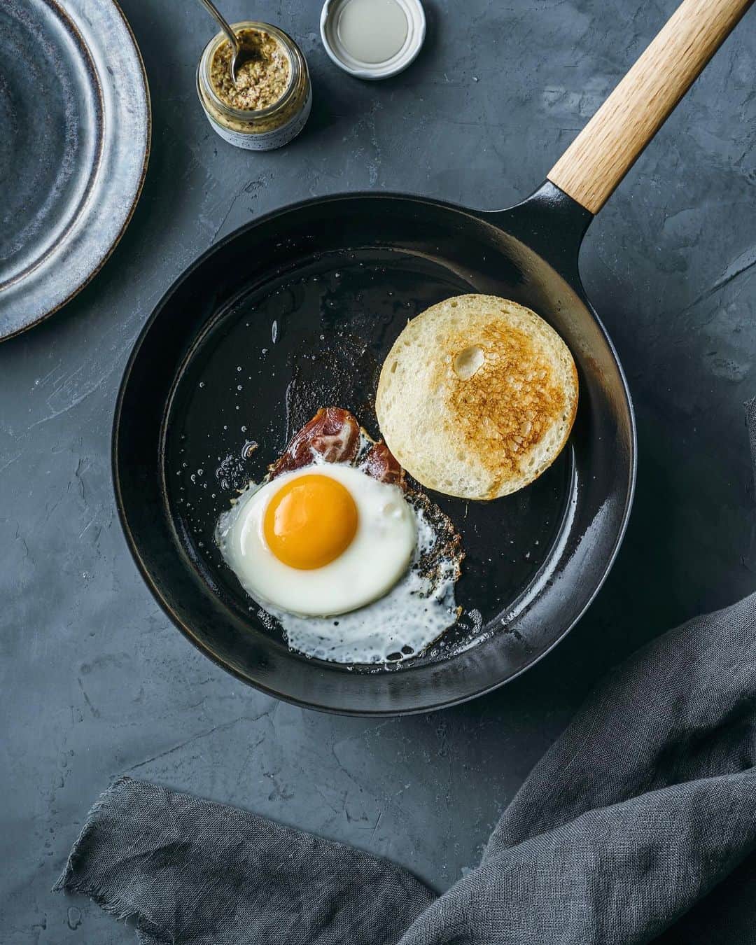 Nanaのインスタグラム：「VERMICULAR'S FRYING PAN 24 DEEP  注文していたものがやっと手元に。 TURKを6年くらい？使ってきて 特に不満はなかったのだけど 公式HPのビジュアルに惹かれてしまい。 届いてみたら、持ってるTURKとそれほどサイズが変わらなくてどうしよう💦ってなったのだけど、使ってみたら煮物もできるし、揚げ物も良さそうだし、TURKよりも用途は幅広そう◎ 目玉焼きも、絶妙な焼き加減で、美味しく焼けた🙌 というわけで久しぶりのパン。 . . ポットも持ってるので、上手に使い分けたいな。 . . TWの方に上げたら質問を多くいただいた。それだけみんな気になっているフライパンなのだなぁと。 . 使い始めたばかりだけど、現時点で思うのは、HPなどに書かれている情報はその通りだなということ。お手入れ方法も、使い心地も。 . TWにも上げているので参考になれば嬉しいです。 . . 写真は横位置で撮ったのだけど 縦にしたくなって縦位置に。 . . #バーミキュラ好きと繋がりたい  .」