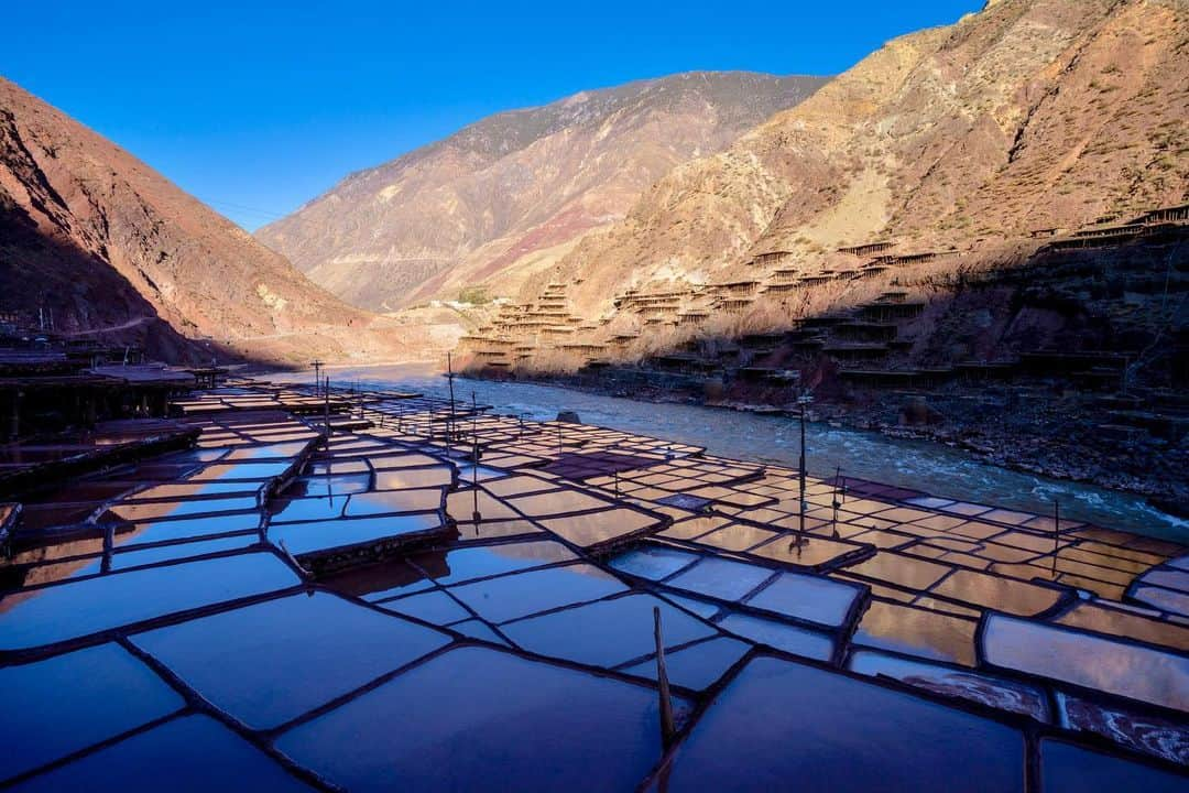 Michael Yamashitaさんのインスタグラム写真 - (Michael YamashitaInstagram)「The ancient salt terraces of Yanjin, Tibet, along Route 318 of the Tea Horse Road, cling to sheer slopes on both banks of the Mekong River. Salty water is pumped up from wells under the riverbed to fill the 3,000 multi level wooden platforms covered in local red clay. It takes 2 weeks of wind and sunshine to evaporate the brine leaving layers of crystallized white salt. In operation for some 1200 years, this is the only place in the world where river brine is processed in this unique way.  #salt #saltpans #teahorseroad #chamagudao #tibet #tibetan #mekong #lancangjiang」6月17日 4時16分 - yamashitaphoto