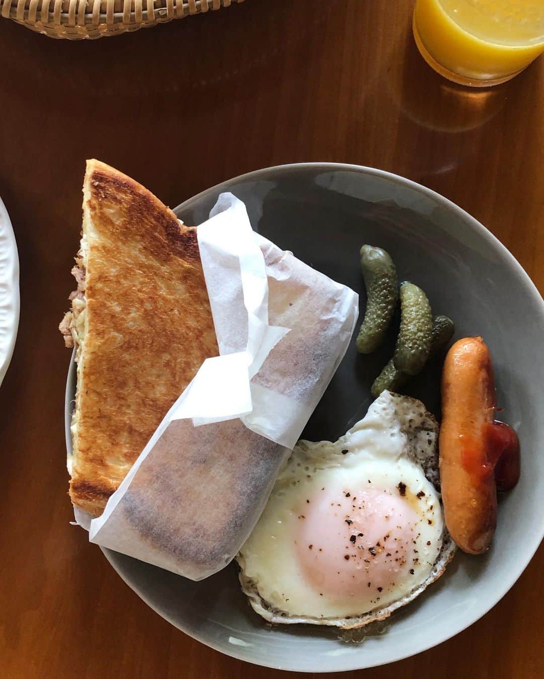 のインスタグラム：「今朝はホットサンド。 自家製プルドポークとコールスロー、チーズで、ビーフでなくザワークラフトでないけど、ルーベンサンドイッチ風。  ホットサンドは専用のものを持っていないのでいつもフライパンで。ヘラでぎゅっーと押し続けたりするけど、手を離したい時は重い鍋をのせちゃう。（ベーコンプレスというのも持ってるけど）バターがしみてパンはサクッと焼き上がり、中身は温まりチーズはとけていい感じに。おすすめですよー！  目玉焼きの担当は完全にバトンタッチ。 ほんの少しの水をさして蒸し焼きバージョン。割って卵をフライパンに落とし、卵の殻に水を入れてる？！感心！　中からは黄身がとろ〜り😋」