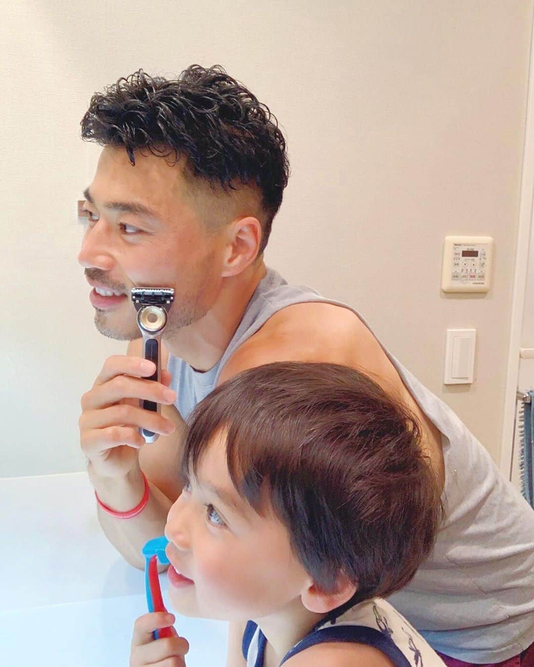 エリナ シルカのインスタグラム：「真似っこ息子😂🪒　山田ディーと同じ事がしたいお年頃。クリームもつけて、一緒に髭剃り〜！(息子のはもちろんオモチャのシェーバー😏) 山田ディーのリアルシェーバーは父の日でプレゼントした　@gillettejapan の　Heated Razor. ラガーマンでタフなイメージなのにお肌弱めな山田ディー。使ってみるとホットタオルみたいなホワホワ暖かくなる感じらしく、力入れないでも綺麗に剃れたみたい。実際に使い始めてから顔も切ってない。ニヤリ😁　毎年悩む父の日プレゼントは今年はバッチリでした〜！いえーい✌️ #Thinkingofdad  #父の日を祝おう  #温熱シェーバー  #ヒーテッドレーザー  #ジレット  #Gillette  #父の日 #お父さんに温もりを届ける  #父の日プレゼント  #pr」