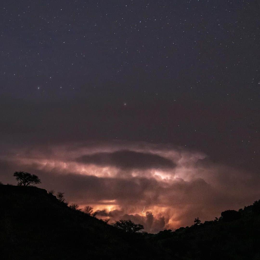 National Geographic Travelさんのインスタグラム写真 - (National Geographic TravelInstagram)「Video and photo by @babaktafreshi | This is a time-lapse video of what I experienced near midnight last May in West Texas. Red sprites are large-scale electrical discharges occurring in clusters about 50 to 90 kilometers (31 to 56 miles) above the ground. They appear above massive storm clouds. Swipe for a close-up photo of the far storm, 100 to 200 miles away, responsible for this. The time-lapse video briefly freezes on the sprites so you can see them better. To the unaided eye, they are usually a featureless, colorless flashing patch of gray. Most people miss them unless they are looking for them patiently. Music by Tonelabs Studio.  Explore more night wonders @babaktafreshi. #redsprites #atmospheric #timelapse #twanight」6月19日 1時46分 - natgeotravel