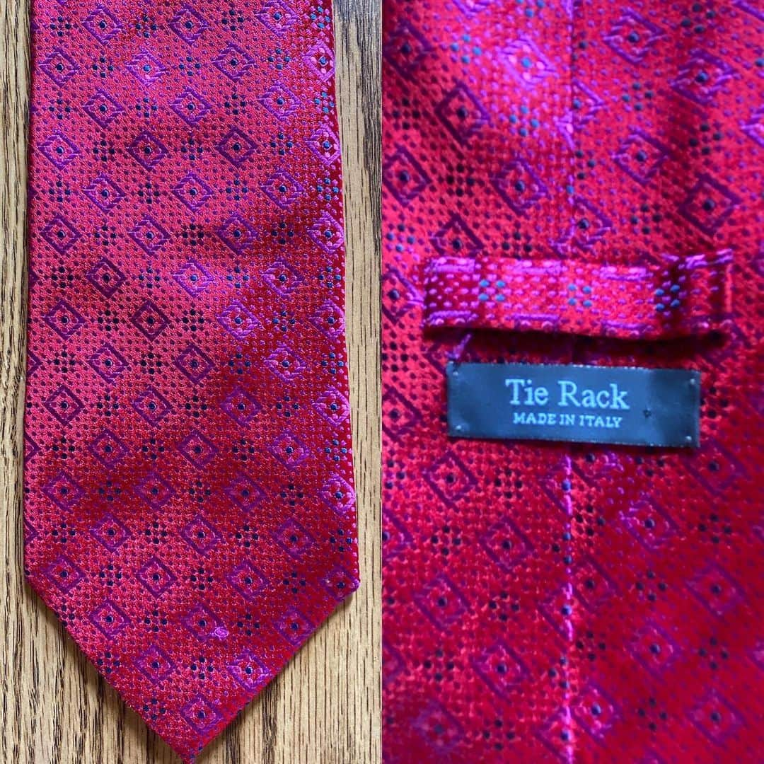 スティーヴン・フライのインスタグラム：「A Tie Rack edition today. Older viewers will remember how every High Street and railway station used to boast a Tie Rack store. Some were little more than booths or kiosks. Along with Sock Shop the chain exemplified a corner-turning moment in 80s and early 90s retail style and habits.  Pic 1 (swipe left) shows a standard Tie Rack tie, with a standard Tie Rack label. Fine in its way – has a pleasing mauve sheen when you turn it in the light.  Pic 2 displays a “Primavera For Tie Rack”. Was Primavera (the Italian for “spring”) an in-house design studio, I wonder? Did the extra name on the label indicate a “designer tie” with a corresponding hike in price? The word “designer” was beginning to be prepended to everything from sunglasses to boxer shorts back then.  Pic 3 shows two “Charleston Tie Rack” specimens.  Swipe left again for a “Chevalier” tie which looks to be greatly influenced by Versace (yes, doesn’t it need a damned good steam?) Pic 5 is “Angelo Bosani”. I wonder if Signor Bosani designed exclusively for Tie Rack? Certainly if you search for his work on eBay and elsewhere they all seems to be Tie Rack items.  Can we discern a distinct difference according to label? Every one of them is 100% silk and all declare themselves to be made in Italy (except the Chevalier which doesn’t reveal its origin). I would say the two Charlestons and the Primavera have a certain something in common, an almost watercolour effect perhaps, whereas the Pic 1 Tie Rack, the Chevalier and the Angelo Bosani are all individual unto themselves.  It’s of no great matter, doubtless some marketing figure decided that there should be this variation in labelling. Tie Rack has gone to retail heaven where it is kitting out the angels in good, but not great, fine but not fabulous, quality but not costly, neck wear. I wish them a blissful eternity, or as Horatio almost phrased it to the dying Hamlet, “Good night, sweet Tie Rack, and flights of angels sing thee to thy rest.”」