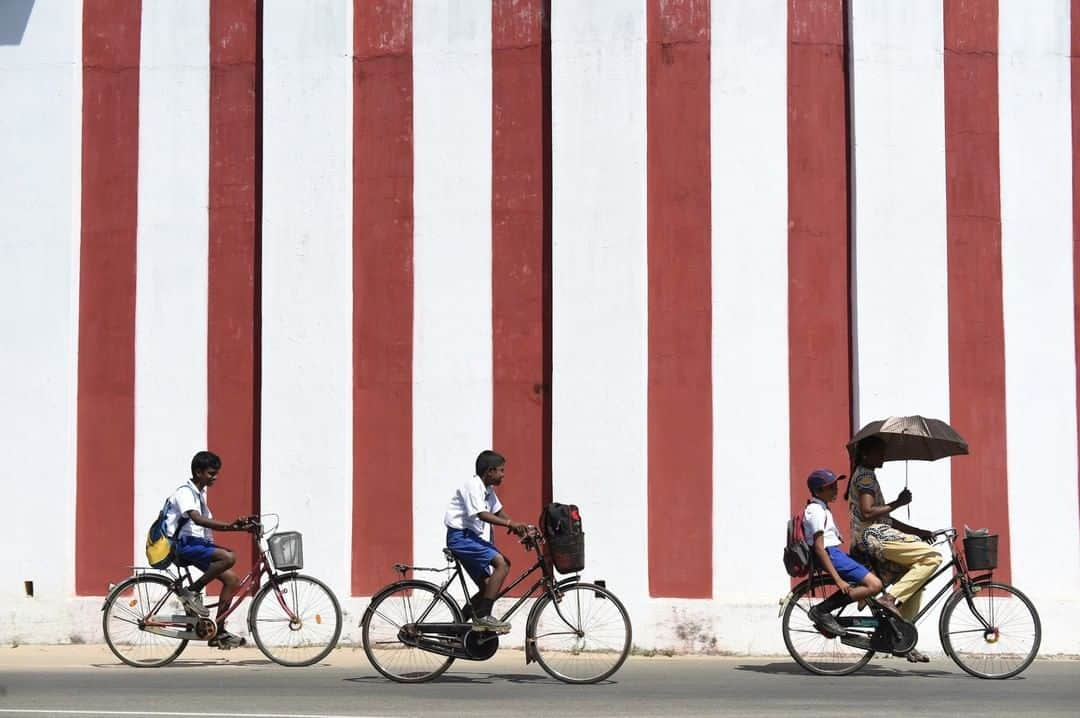 National Geographic Travelさんのインスタグラム写真 - (National Geographic TravelInstagram)「Photo by @amivitale | Students bicycle past the Nallur Kandaswamy Kovil Hindu temple in Jaffna, Sri Lanka. Built in the 16th century, the temple is one of the most significant religious sites in the island nation. The presiding deity is Lord Murugan, the god of war. Learn more about Sri Lanka by following @amivitale and reading the @natgeo article, "Can Sri Lanka Hold On to Its Fragile Peace?" @thephotosociety #srilanka #Trincomalee #bicycles #students #LordMurugan」6月21日 17時08分 - natgeotravel