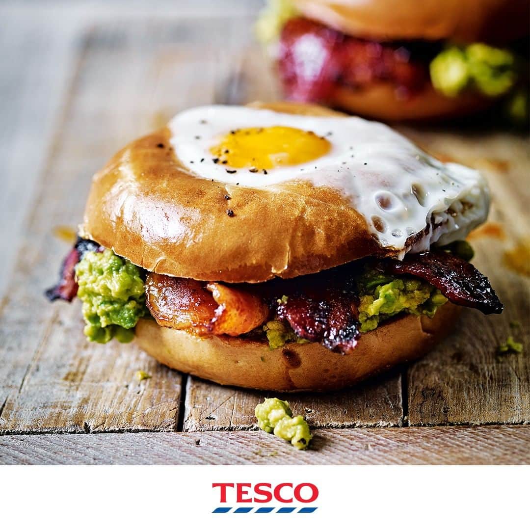 Tesco Food Officialさんのインスタグラム写真 - (Tesco Food OfficialInstagram)「A real dad-sized brunch.  Serve up something special for #FathersDay like this grab-and-go guac and bacon bagel. Go go go!  Ingredients 4 bagels, sliced in half horizontally 2 avocados 1 lime, juiced 8 cherry tomatoes, roughly chopped 4 tsp chipotle chilli and paprika paste 4 tsp maple syrup 12 rashers streaky bacon 1 tbsp olive oil 4 eggs  Method 1. Preheat the oven to gas 4, 180°C, fan 160°C and line a baking tray with foil. If the bagel holes are small, cut away some of the centre.  2. Mash the avocado with the lime juice and a little salt. Stir in the tomatoes and set aside.  3. Mix the chipotle paste and maple syrup. Put the bacon on the lined tray and brush one side with half the chilli-maple paste. Bake for 8-10 mins, until just crisp, then turn over and brush with the remaining paste. Bake for a further 5-7 mins.  4. Meanwhile, in a large ovenproof frying pan set over a high heat, toast the cut sides of the 4 bagel bases for 1-2 mins, until golden. Remove and spread with the guacamole.  5. Preheat the grill to high. Heat the oil in the frying pan over a medium-high heat and add the bagel tops, cut-side down. Break an egg into each hole and cook for 10-12 mins, then put the pan under the grill, until the tops are cooked to your liking*. Put 3 bacon rashers on each base, then sandwich with the eggy bagel top; season.」6月21日 19時00分 - tescofood