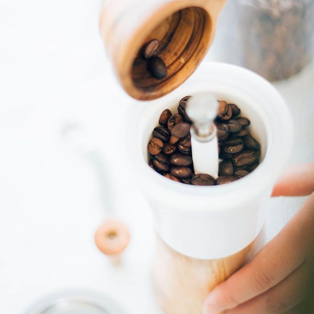 UCC上島珈琲さんのインスタグラム写真 - (UCC上島珈琲Instagram)「.﻿ ＼ @hario_official さんのコーヒー器具「セラミックコーヒーミル・ウッド」のご紹介✨／﻿ ﻿ セラミックとオリーブウッドを組み合わせた「セラミックコーヒーミル・ウッド」をご紹介します☕﻿ ﻿ セラミックコーヒーミル・ウッドはボディにオリーブウッドとセラミックを採用し、インテリアとしても存在感のある美しい曲線が特徴的😍﻿ ﻿ セラミック製の臼を使用することで、摩擦熱が発生しにくく、熱によるコーヒー粉へのダメージを防いでくれるんです👏﻿ 持っているだけでテンションの上がる、オシャレなコーヒー器具ですね🌼💕﻿ ﻿ 詳しくは「セラミックコーヒーミル・ウッド」で検索してね🎵﻿ ﻿ #セラミックコーヒーミルウッド﻿ #コーヒーミル﻿ #セラミックコーヒーミル﻿ #オリーブウッド﻿ #コーヒー器具﻿ #木のぬくもり﻿ #インテリア﻿ #おしゃれ﻿ #お気に入りアイテム﻿ #シンプル﻿ #ハンドミル﻿ #便利アイテム﻿ #家淹れコーヒー﻿ #コーヒー﻿ #コーヒーブレイク﻿ #コーヒータイム﻿ #コーヒーのある暮らし﻿ #コーヒー好きな人と繋がりたい﻿ #コーヒー大好き﻿ #コーヒー豆﻿ #コーヒー部﻿ #coffee﻿ #coffeetime﻿ #coffeelover﻿ #coffeegram﻿ #coffeestyle﻿ #ucc﻿ #ucc上島珈琲﻿ #uccコーヒー」6月23日 17時00分 - uccueshimacoffee
