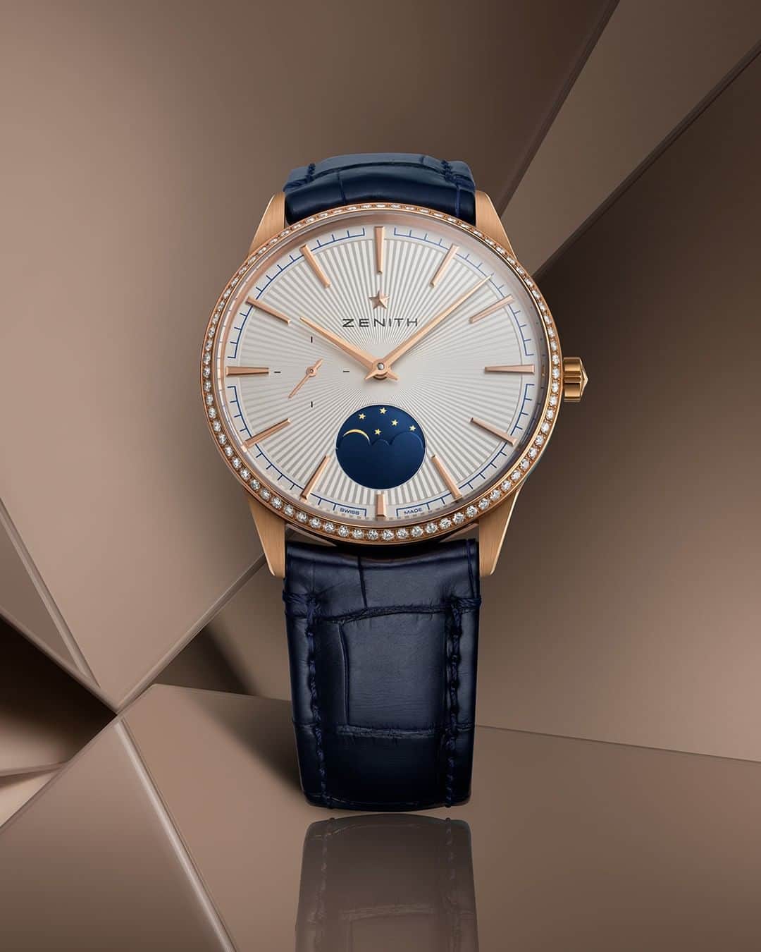 ゼニスのインスタグラム：「#Elite: Bringing out the poetic side of the moon with the Elite Moonphase in a 36mm rose gold case with a diamond-set bezel and radiant silver dial.  #Zenith #ZenithWatches #Watches #Watch #Watchesofinstagram #Watchfam #WatchoftheDay #Luxury #WatchAddict #Watchcollector #Horology #DailyWatch #Moonphase #Gold #Diamonds」