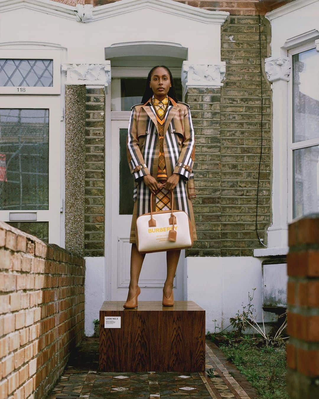 のインスタグラム：「Tanisha, Copy & Translations, East London . ‘For the lookbook, I called upon the incredible talent at Burberry to open their doors and be a part of this journey – each interpreting the looks in their own unique way outside in the landscapes of London and beyond.’ - #RiccardoTisci . Tanisha wears a birch brown check trench with a bright orange cut-out argyle jacquard vest, plaid shirt and pencil skirt from the upcoming collection, arriving in November .  #BurberryPreSS21」