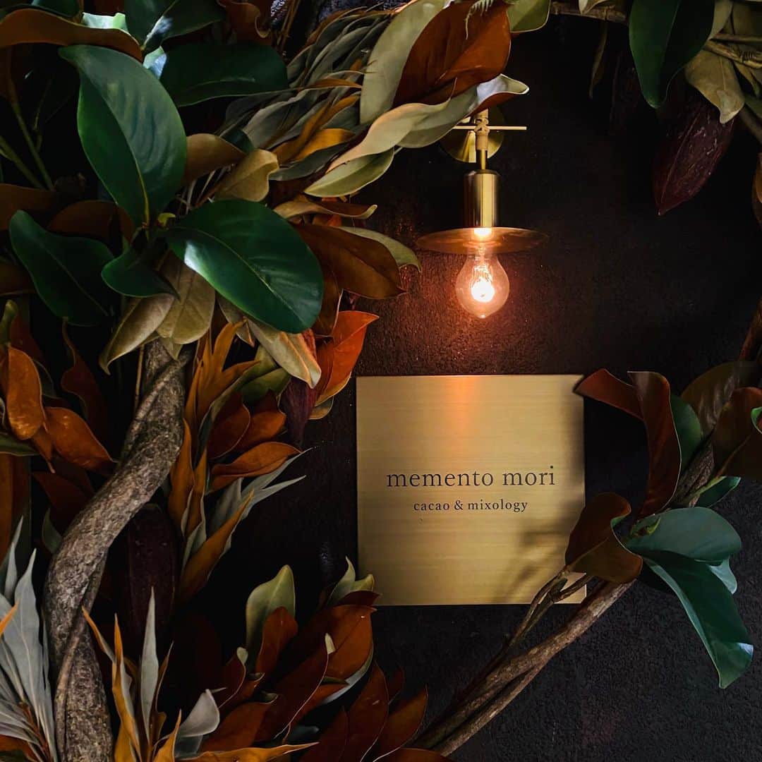 林信行のインスタグラム：「#MementoMori yet another must-visit bar in Tokyo! 東京にまたひとつ、ステキなbarが誕生しました。 話題のスポット、虎ノ門ヒルズビジネスタワーにできた「memento mori」。 カカオのボタニカル（カクテル）をコンセプトの中心に据えたmixologyグループの７店舗目。 カカオベースのカクテルは、六本木のmixology experienceでも、たまに飲んでいたが、この店ではそれがコースで楽しめる。チョコレートペアリングコースもある。さらにお酒が苦手な人、「今日は飲めない」人にはmocktailのコースもある。  店内はそこかしこにカカオの実。 メニューの冒頭にもエピローグとして、人類とカカオの歴史が描かれている （字は読まなかったー汗。こういうお店に深みを与えてくれるディテールって大事だと思う！そういう意味では聞かなかったけどMemento Mori、つまり「己がいずれは死ぬ存在だということを忘れるな」というラテン語の店名も意味深だ）。  イロハとラベルづけされたガラス小瓶にもさまざまなカカオのエキスが入っているという。 なんだか見ているだけで楽しそうな気持ちになってくる。  残念ながら今日は22時までに帰らないといけなくて（22時半になってしまったがギリギリ用事は間に合った）、カクテル２杯だけ。 １杯目は、私が小学１～２年を過ごしたエクアドル産のカカオとトニックのカクテル。これがカカオのカクテル？という透明感のあるカクテルだけれど、上にカカオのパウダー？（破片）がのっていてしっかりと香りがする。予想外のカカオカクテルで先制パンチをくらった感じ。楽しく、涼しく、すっきり美味しかった。 ２杯目はその名もBrazilian Negroni。強いのが好きかと聞かれて出された２択の１つ。こちらも、次回必ず頼む１杯。 というか、次回はしっかりコースで頼みたい。 実は前回、虎ノ門横丁に行った時にも寄ろうと思ったのだけれど、混んでいたので諦めた。今回も飲んでいたら混み始めた。午後２時からやっているそうなので、次は普通の人がまだ働いている時間帯を狙って来ようかと思う。  ただ、１度しか会ったことがなかったのに、よく話ではでてくる南雲さんが日曜だというのにお店にいてカクテルをつくってくれていた。会うのはすごく久しぶりでお互い顔を覚えていなかったけれど、私の名刺を出したら覚えていてくれて感激。 また遠からず行かないと…  最初、きっかけづくりにところどころ諏訪さんの名前を出させてもらいました（諏訪さんありがとう！）」
