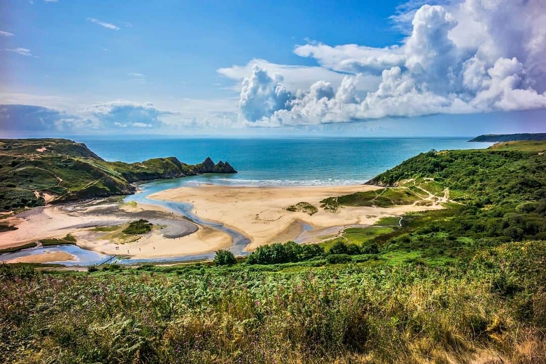Lonely Planetのインスタグラム：「Are you thinking about your next escape to the sea? From sweeping Cornwall beaches to remote Scottish strands, visitors to the UK will never be short of epic coastlines to visit. Tell us in the comments your favourite UK beach.   The beach you see here, Three Cliffs Bay on the Gower Peninsula, is named for the pyramid-like sea cliffs pierced by a natural arch that juts out into the water. It's considered to be one of the most beautiful beaches in Britain, and is particularly impressive when viewed from the impossibly picturesque ruins of 13th-century Pennard Castle.  Tap the link in our bio to find out our top 11 favourite beaches across the United Kingdom.」