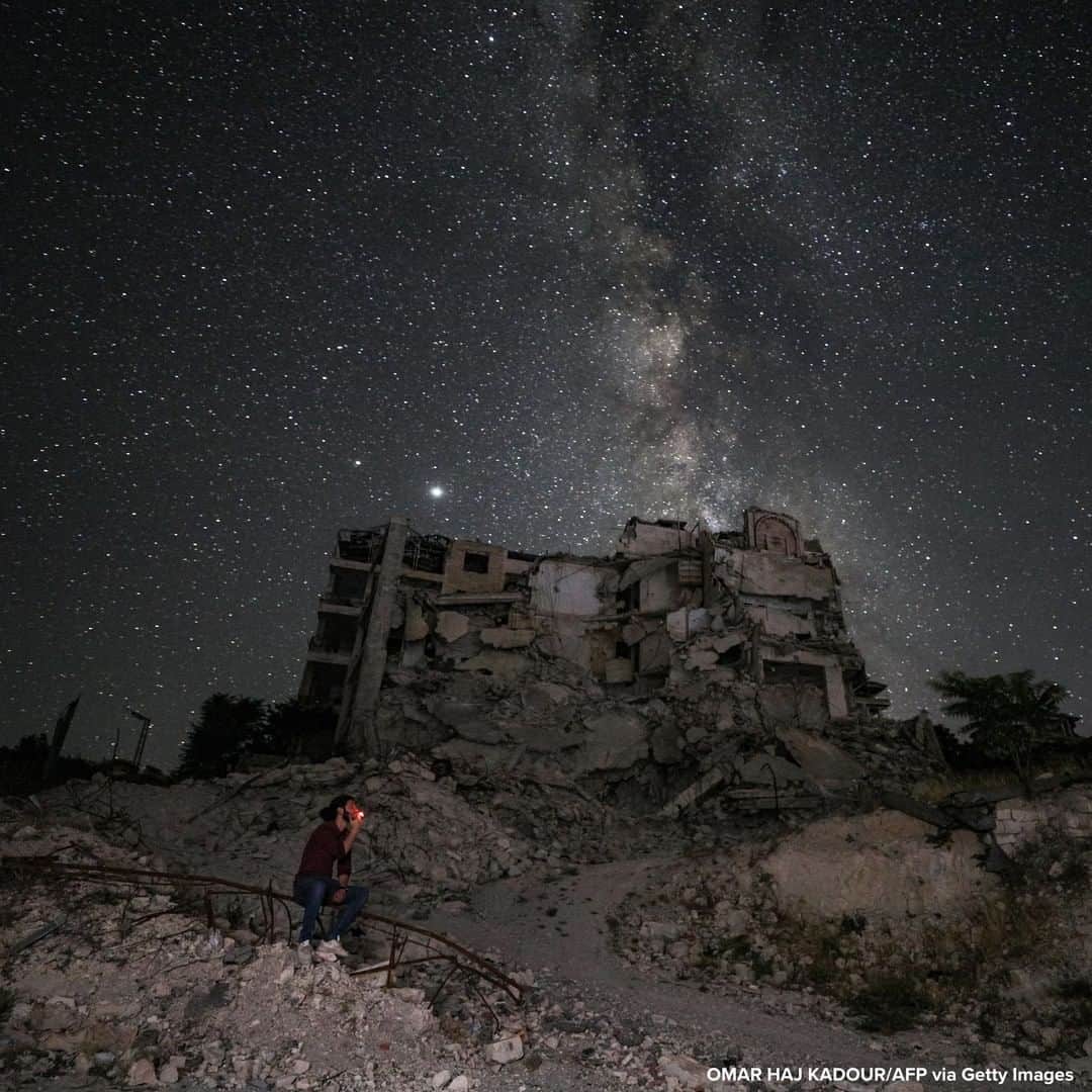 ABC Newsさんのインスタグラム写真 - (ABC NewsInstagram)「Man sits amid buildings destroyed by bombardment in Syria's rebel-held northwestern Idlib province, as the Milky Way is seen in the night sky above. #syria #milkyway #nightsky」6月29日 18時52分 - abcnews