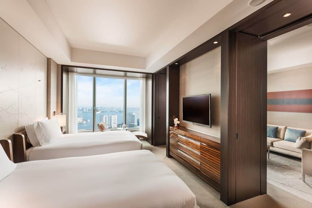 Conrad Tokyoのインスタグラム：「高さ約3メートルの大きな窓から降り注ぐ自然光と眼下に広がる絶景が都会のオアシスを感じさせます。 Relax in a Bay View Suite and take in panoramic views overlooking the Royal Hamarikyu Gardens and Tokyo Bay.」