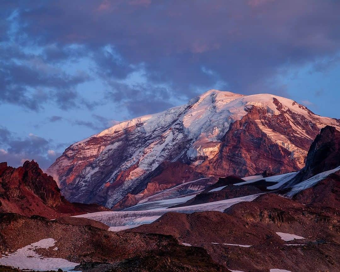 National Geographic Travelさんのインスタグラム写真 - (National Geographic TravelInstagram)「Photo by @stephen_matera | The sun sets over the summit of Mount Rainier in late summer. Mount Rainier receives incredible annual snowfall, averaging 640 inches per year at Paradise, at 5,400 feet (1,646 meters) on the south side of the mountain. Higher elevations generally will receive more precipitation, allowing for the creation of large glaciers on all sides of the mountain. The Carbon Glacier (the upper portion of which is shown on the top left of the mountain in this image) on the northwest side is over five miles (eight kilometers) long and extends down to an elevation of 3,500 feet (1,067 meters), which is the lowest elevation glacier in the contiguous United States. Follow me @stephen_matera for more images like this from Washington and around the world. #glacier #volcano #mtrainier」6月29日 21時08分 - natgeotravel