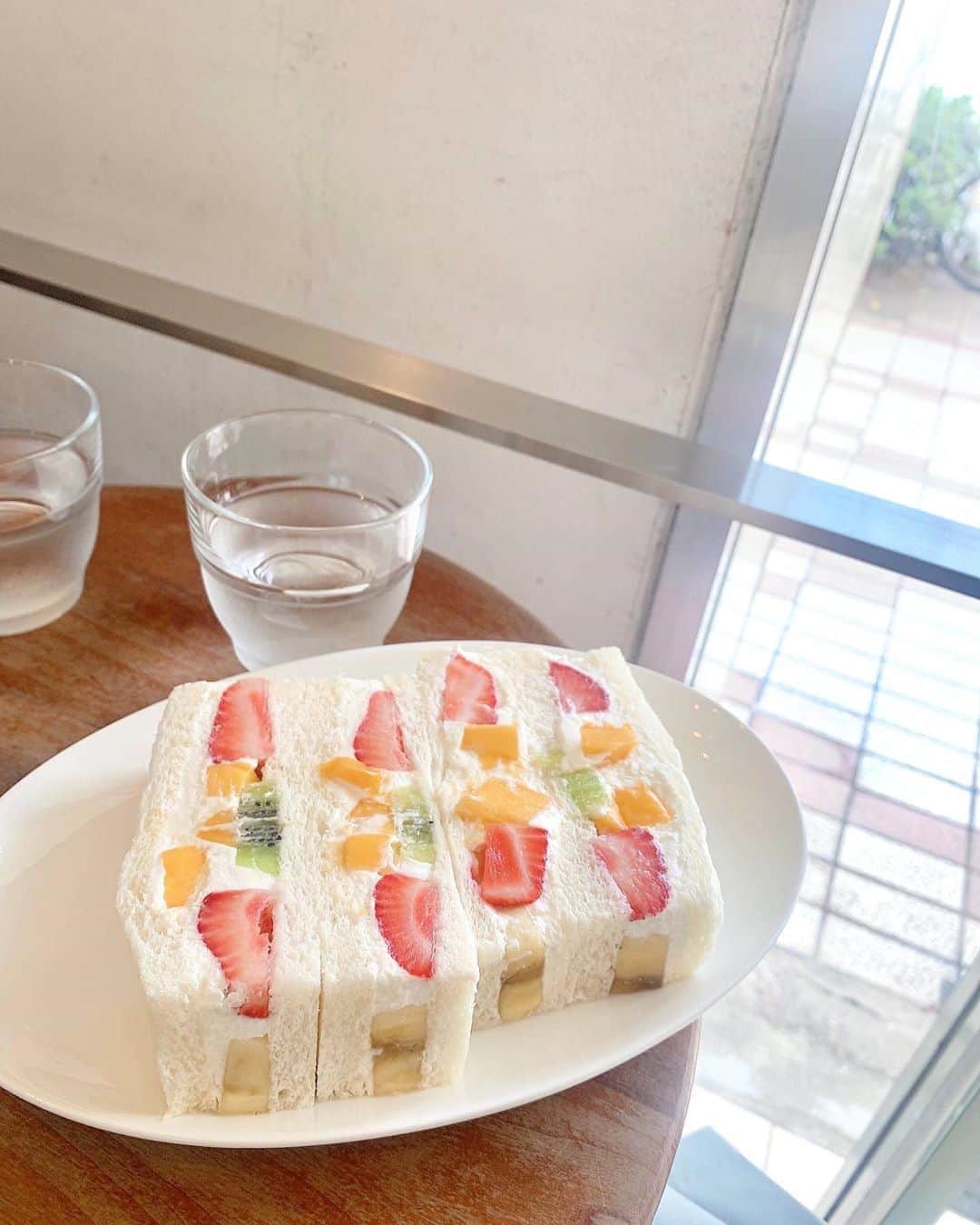 のインスタグラム：「#ななせのフルーツサンド記録 🍓🍞💭 ﻿ ﻿ 今回は『フルーツカフェフルータス』﻿ というお店のフルーツサンドです🐨🥛 ﻿ ﻿ ﻿ ﻿ 見た目は 上品さもありながら、ぎっしりとフルーツがサンドされていて、絵に描きたくなる理想系フルーツサンド！﻿ ﻿ ﻿ こんなに色んなフルーツが入っていると、普通なら口の中が忙しくなるんだけど、これはめちゃくちゃバランスが良くて全部があわさって美味しさが増してる！﻿ ﻿ こだわられてるなぁ…すごい、、т  ̫ т✨﻿ ﻿ ﻿ ﻿ ﻿ あっさりなのにコクがあって﻿ 満足感のあるフルーツサンドでした！﻿ ﻿ ﻿ 友達と﻿シェアしたワッフルも美味しかったよ！ ﻿ ごちそうさまでした🌷﻿☺︎ ﻿ ﻿ ﻿ ﻿ ﻿ そろそろフルーツサンドの連載のお仕事こないかなぁ〜 😚笑﻿ ﻿ ﻿ ﻿ ﻿ ﻿ #フルーツサンド#フルーツサンド部#フルーツカフェ#フルータス #ななせのcafe巡り#fruitsandwich#ごち」