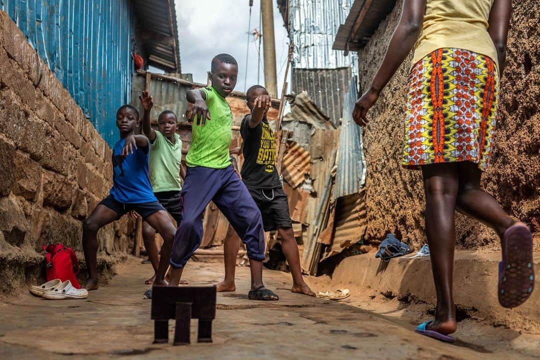 National Geographic Creativeさんのインスタグラム写真 - (National Geographic CreativeInstagram)「Photo by @nicholesobecki  Eugene Ochieng and his fellow dancers practice ballet through an online class in an alley outside his home in Kibera, the largest of more than 100 informal settlements in Nairobi. The coronavirus pandemic is forcing children around the world to stay home and learn remotely, but Eugene faces huge obstacles to this: no computer, limited access to the internet, and little space to practice once his studio at Project Elimu closed its doors. Follow me on @nicholesobecki for more coverage of the Covid-19 crisis in Kenya.」7月3日 23時53分 - natgeointhefield