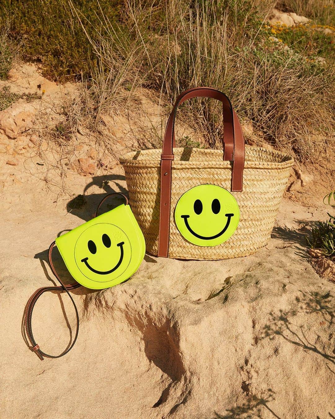 のインスタグラム：「LOEWE Paula’s Ibiza 2020 accessories featuring Smiley®. A basket bag woven from palm leaves is emblazoned with an oversized yellow patch. On the Heel mini the Smiley® is as big as the bag itself.  Available exclusively on loewe.com  Photography @RosieHarrietEllis  #LOEWE #LOEWEpaulas  LOEWE will be donating 40 euros for every product sold in the Paula’s Ibiza fashion collection to educational projects for children affected by COVID-19 between April and August 2020 in LOEWE stores and on loewe.com.」