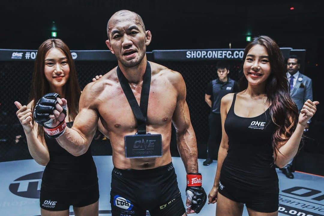 のインスタグラム：「親、コーチ、無名の人…ONE選手が語るヒーロー ONE Championship  ONEチャンピオンシップのアスリートは、ファンや次世代の格闘家達の間ではヒーローとされているが、彼ら自身にも尊敬しているロールモデルがいる。 両親や、正義のために立ち上がった人々、コーチやもしくは名も無き人々らだ。 ONEアスリートに、人生に影響を与えたヒーローについて聞いた。  岡見勇信  「今でも私の記憶に強烈に残っていて、困難な場面に遭遇した時には必ず思い起こすことがある。それは私の父の姿」 「父は６年前に、癌で亡くなった。進行が早く、末期癌と診断されてからわずか３ヶ月ほどだった」 「癌性疼痛で壮絶な痛みが24時間つきまとい、心身ともにボロボロの状態。屈強な身体が自慢だった父が、痛みが強く自力で歩くこともままならず車椅子での通院。そんな状況でも、たとえわずかでも生存率が上がるなら、と父は『手術を受けます』と医師の前で明言した」 「家族のために、生きることを諦めなかった。手術どころではない、何をしてもどんなことをしても消えない痛みと戦っていたのに。その勇気ある姿は、目に焼き付いていて離れない」 「後にその手術は、父の身体的状況から耐えられないと判断されドクターストップに。それほどまでに悪化していたにも関わらず、自分のためではなく家族のために、父は生きることを諦めなかった」  「最期まで、周りに気を遣わせまいと笑顔を見せ、冗談を言う父の姿に感服した。私には真似できない」 「私は自分の弱さに飲み込まれそうになった時は、どんな辛い状況でも周囲への優しさを忘れず、勇ましく行動した父のあの姿を思い出す」 「身をもって示してくれた生きざま。 父以上の勇敢なヒーローにはまだ出会えていない」  #onechampionship #weareone #exfight #ldh #ldhmartialarts #underarmour #mma #格闘技 #父」