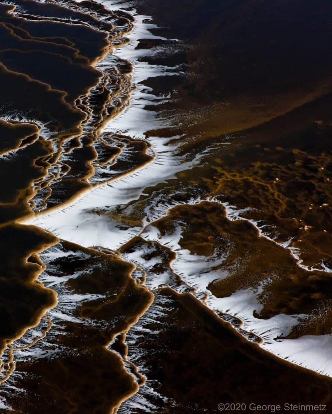 ナショナルジオグラフィックさんのインスタグラム写真 - (ナショナルジオグラフィックInstagram)「Photo by George Steinmetz @geosteinmetz  The level of the Dead Sea is dropping by about three feet (one meter) per year, due to freshwater diversions for human use. The lowest point on Earth is now separated into two depressions. The southern lobe has been converted into evaporation ponds for industrial use. On the Israeli side, shown here, that includes coffee-colored cascades of brine to concentrate and extract products ranging from potash for fertilizer to flame retardants to batteries. To view more of our world from above, follow @geosteinmetz.」7月8日 3時37分 - natgeo