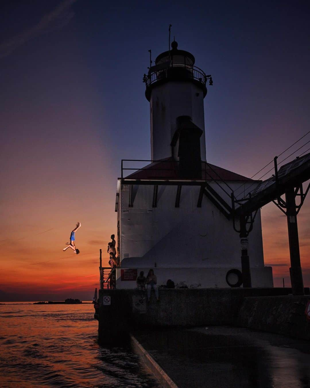 National Geographic Creativeさんのインスタグラム写真 - (National Geographic CreativeInstagram)「Photo by Keith Ladzinski @ladzinski / Summer time in the Great Lakes is all about escaping the heat and enjoying the water. A small group of teenagers seen here doing flips into the lake off of the Michigan City Lighthouse at twilight. I used a small flash to illuminate the scene and freeze the action, good times on the southern shores of #LakeMichigan. To see more photos from this assignment please visit @ladzinski」7月8日 5時41分 - natgeointhefield