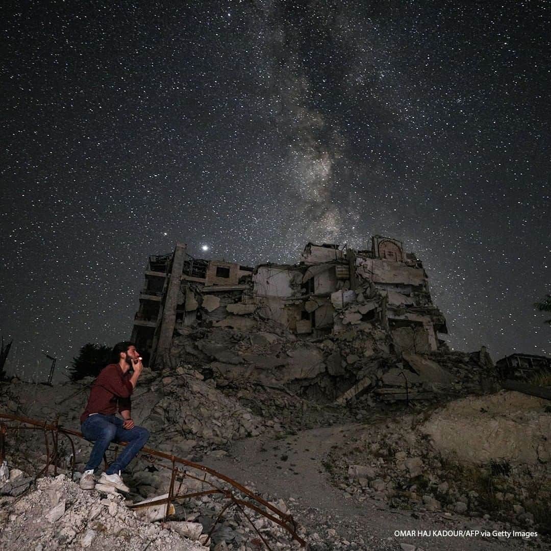 ABC Newsさんのインスタグラム写真 - (ABC NewsInstagram)「A long-exposure picture shows a man smoking past buildings destroyed by prior bombardment in the town of Ariha in Syria's rebel-held northwestern Idlib province, as the Milky Way galaxy is seen in the night sky above. #syria #sky #stars」7月8日 18時30分 - abcnews