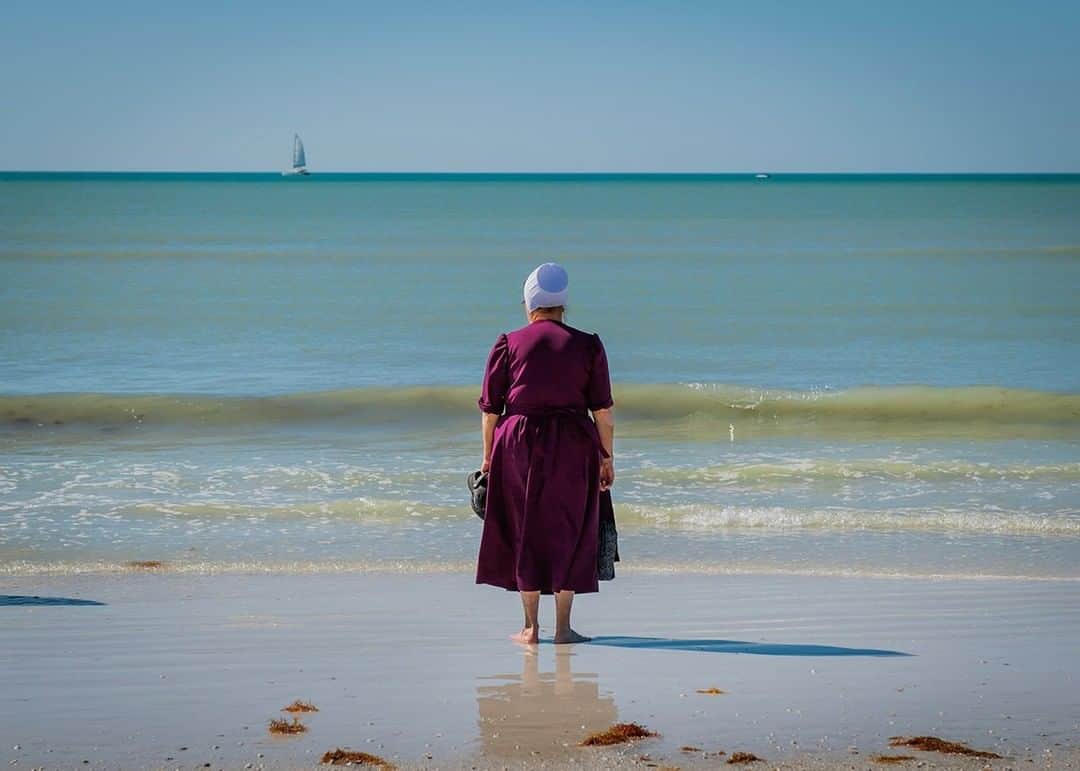 National Geographic Travelさんのインスタグラム写真 - (National Geographic TravelInstagram)「Photo by @dina_litovsky  An Amish woman stands at Siesta Key Beach, Sarasota, Florida. For many decades Amish and Mennonite families from around the United States have been taking winter vacations in Pinecraft, a small neighborhood in Sarasota. The strict rules of Anabaptist life are temporarily relaxed as hard work is replaced by leisure and recreational activities. For more images, follow me @dina_litovsky.」7月9日 9時04分 - natgeotravel
