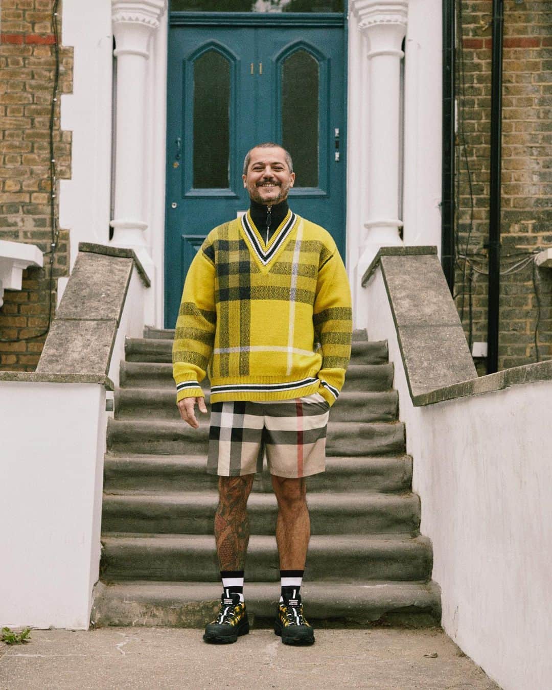 のインスタグラム：「Massimo, Accessories Design, Hackney . Our Spring/Summer 2021 pre-collection lookbook – a celebration of the #Burberry community and our founder Thomas Burberry’s legacy of discovery and exploration . Massimo wears a bright yellow check cashmere wool jacquard reconstructed sweater, shorts and our runway Arthur sneakers from the upcoming collection, available in November . #BurberryPreSS21」