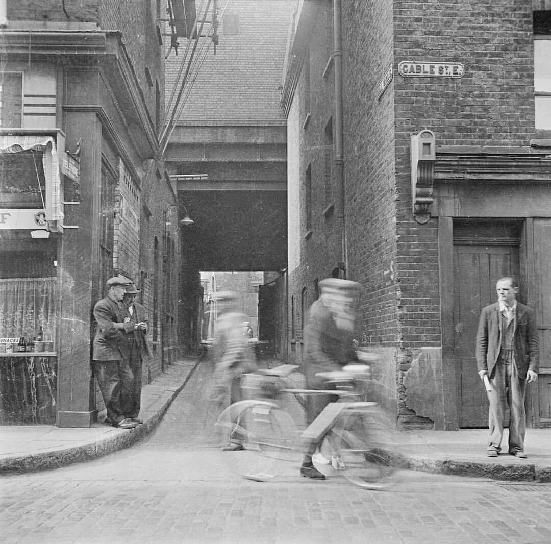 テート・ギャラリーさんのインスタグラム写真 - (テート・ギャラリーInstagram)「More treasures from Tate's Archive today and this week it's Nigel Henderson⁣'s photographs of East London from the late 1940s to the mid 50s. 📸📸📸  ​⁣ ​Henderson was a social and experimental photographer and artist. Exposed to art (and many avant-garde artists) at an early age through his mother's work with Peggy Guggenheim, Henderson paused his artistic career during the Second World War to serve as a pilot in the Coastal Command. He was discharged from his job due to nervous exhaustion but returned to London to study at The Slade.⁣ ​⁣ ​In 1949 his wife, Judith Stephens, a social anthropologist, worked for a social observation organisation in Bethnal Green called 'Discover Your Neighbour', which aimed to capture the everyday lives and experiences of working people. The couple moved to Chisenhall Road in the East End of London and armed with a Roloflex camera, Henderson took documentary style photographs of markets, children, shop fronts, and other scenes of London life amongst the post war, industrial ruins which can be seen here. These outdoor 'little theatres', as Henderson called them, remind us of the joy and hope that can be found all around us in tricky times.⁣ ⁣ These images can be found in Tate's Archive collection: ‘Further papers of Nigel Graeme Henderson (1917-1985)’. Click the link in our bio to explore more.⁣ #TateTreasures ⁣ Photographs showing: part of Cable Street, London; a camera crew filming a girl on an unidentified street; the interior of a barber shop; people sunbathing in a public park; an unidentified woman looking through a shop window; women at an outdoor market stall; detail of a building on Chisenhale Road, London; people waiting outside an unidentified theatre or cinema; a shop front of Hillard & Sons on Mercer Street; a shop front of Ed. G. Russell, newsagents and tobacconist; all photographs [c.1949–c.1956] © Nigel Henderson Estate」7月24日 0時19分 - tate