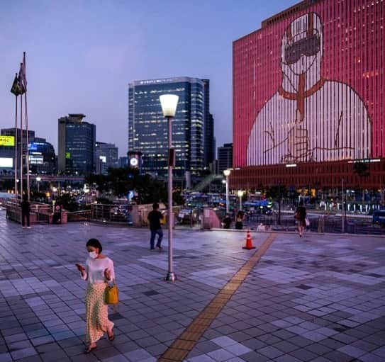 のインスタグラム：「AFP Photo 📷 @edjonesafp - People walk below a display on a building showing messages of support for health workers and the country amid the COVID-19 coronavirus pandemic outside Seoul station on July 8, 2020.」
