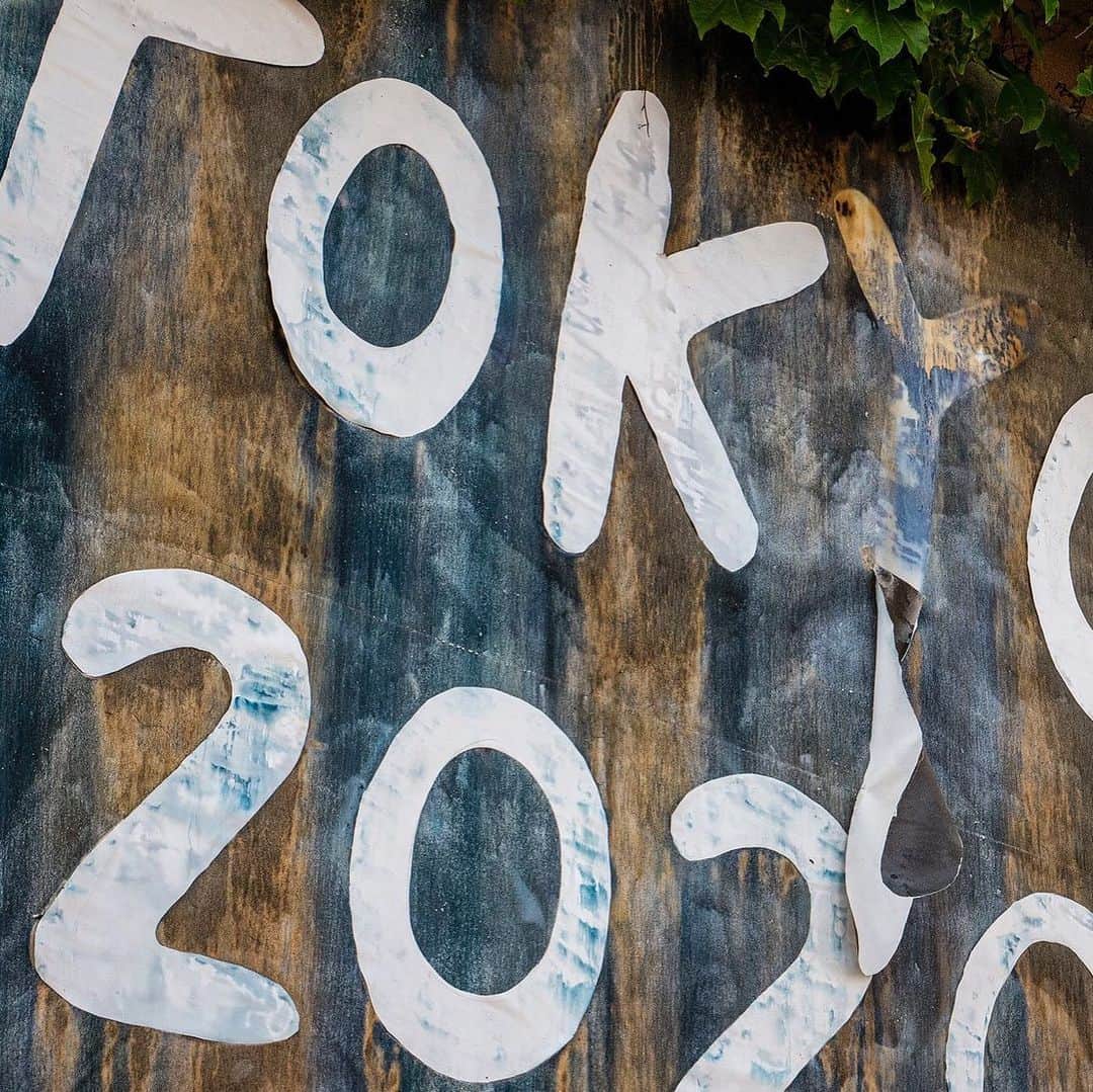 エリイ のインスタグラム：「“May, 2020, Tokyo " 2020  cyanotype print, gelatin, canvas, lambda print    In 2020, the world faces an unprecedented crisis due to the spread of COVID-19. Large cities underwent lockdowns, online systems accelerated, and Tokyo declared a state of emergency for April and May. The virus, in an instant, changed our way of life and our values.    The Tokyo Olympics and Paralympics, intended to be epic celebrations, have now been postponed to 2021. With this, Tokyo 2020, the brand name that the city proudly proclaims, will be repurposed for 2021.   Despite the odds, in this project, Chim↑Pom continues to produce work outdoors. The collective focuses again on the city, where officials urge people to self-refrain from going out by novel assertions of “stay home” and “social distance.”  In a city devoid of many of its functions, what does the outside world under a state of emergency look like? What changes, and what remains the same?  To record this, Chim↑Pom installed billboards painted with cyanotype sensitizer in various locations where traffic dramatically decreased. They left these signboards out for two weeks, printing traces of the unchanged environment—rain, sunlight, wavering shadows—onto the screen, marking the passing of time.   How will society shift after 2021, and how will that affect interpretations of this work? Evoking the various projections of Tokyo 2020 that Japan has and will continue to envision, and the term “new normal” that emerged with corona, this work attempts to draw the “blueprint” for 2020—a year of visions appearing and disappearing—as a billboard.」
