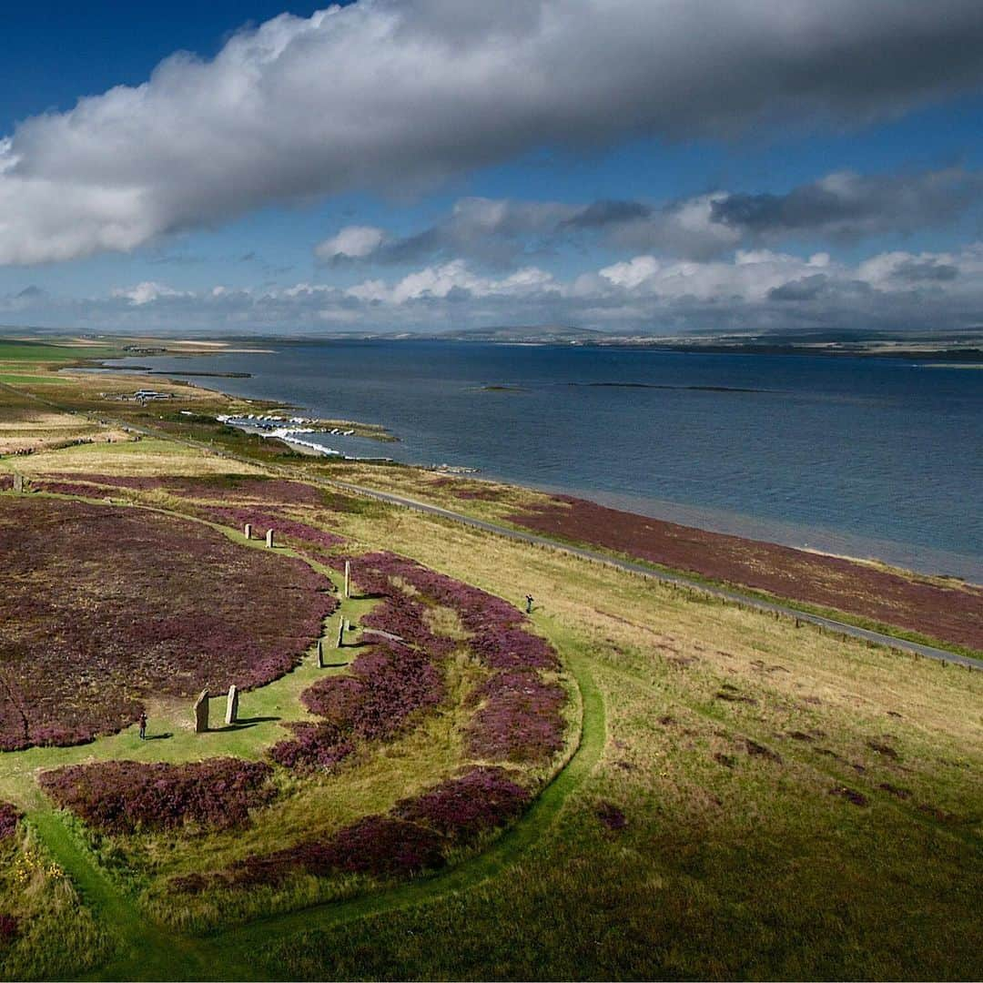 National Geographic Travelさんのインスタグラム写真 - (National Geographic TravelInstagram)「Photo by @JimRichardsonNG  The Ring of Brodgar was enjoying a day in the sunshine, covered with blooming heather, as we sent our camera-carrying kite aloft in a stiff Orkney breeze. From this vantage point it was easy to see the henge, the raised earthen platform with a classic surrounding ditch cut deep into the underlying stone 5,000 years ago. The standing stones came later, added after the henge had already served as a focal point of the Orkney Neolithic community for some time. (On up the hill is another henge that never got any standing stones at all.) Brodgar sits on the narrow strip of land separating lochs Stenness and Harray, making it a natural centerpiece of the surrounding farming community at the time.  Follow me @JimRichardsonNG for more photos from Scotland.」7月11日 1時12分 - natgeotravel