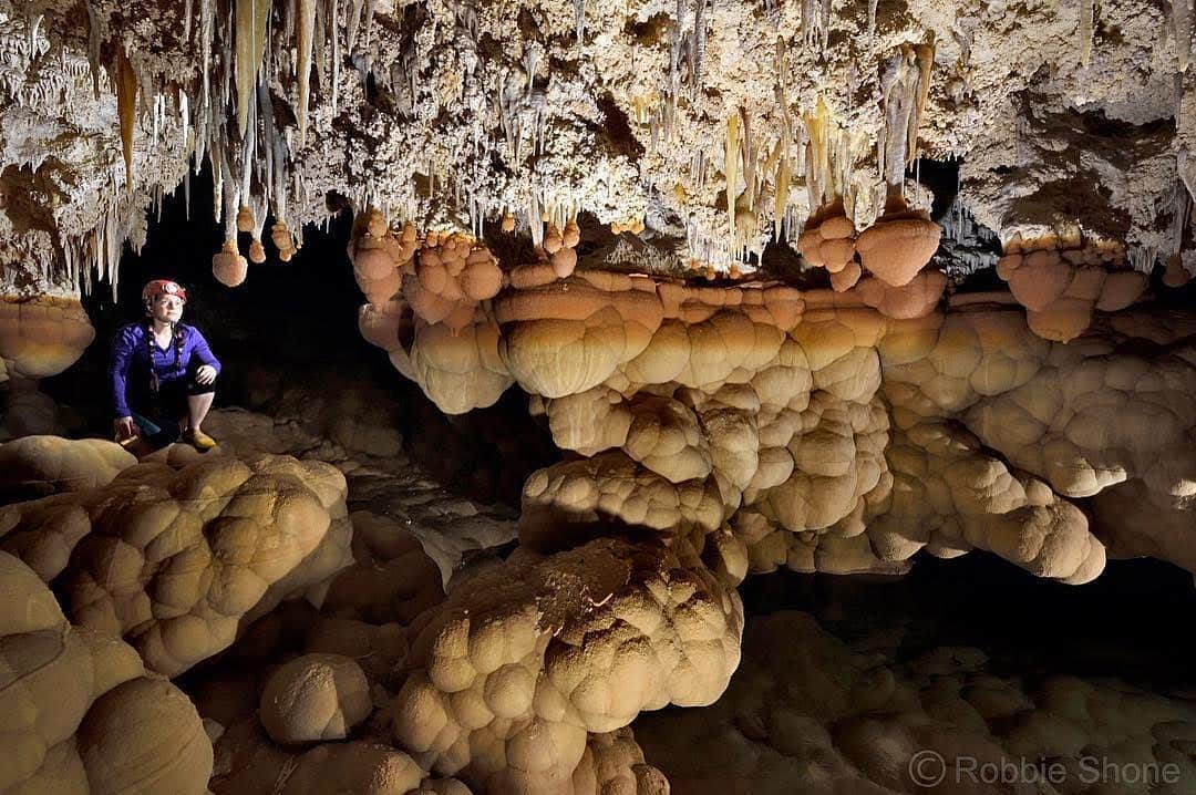 thephotosocietyさんのインスタグラム写真 - (thephotosocietyInstagram)「Photo by Robbie Shone @shonephoto  In Lechuguilla Cave in Carlsbad Caverns National Park, a geologist enters a small chamber containing stunning, cloud-like cave formations known as mammillaries. These formed underwater at times when the lake was much higher than it is today. The formations that look like lion tails (the white stalactites with orange bulbs on the end) formed close to the water’s surface, with the white part being above the water and the orange part being just below the surface. Lechuguilla is a very beautiful and highly protected cave. Access is very strongly controlled and only given to experienced cavers with specific scientific or exploration goals within certain parts of the cave.」7月11日 2時50分 - thephotosociety