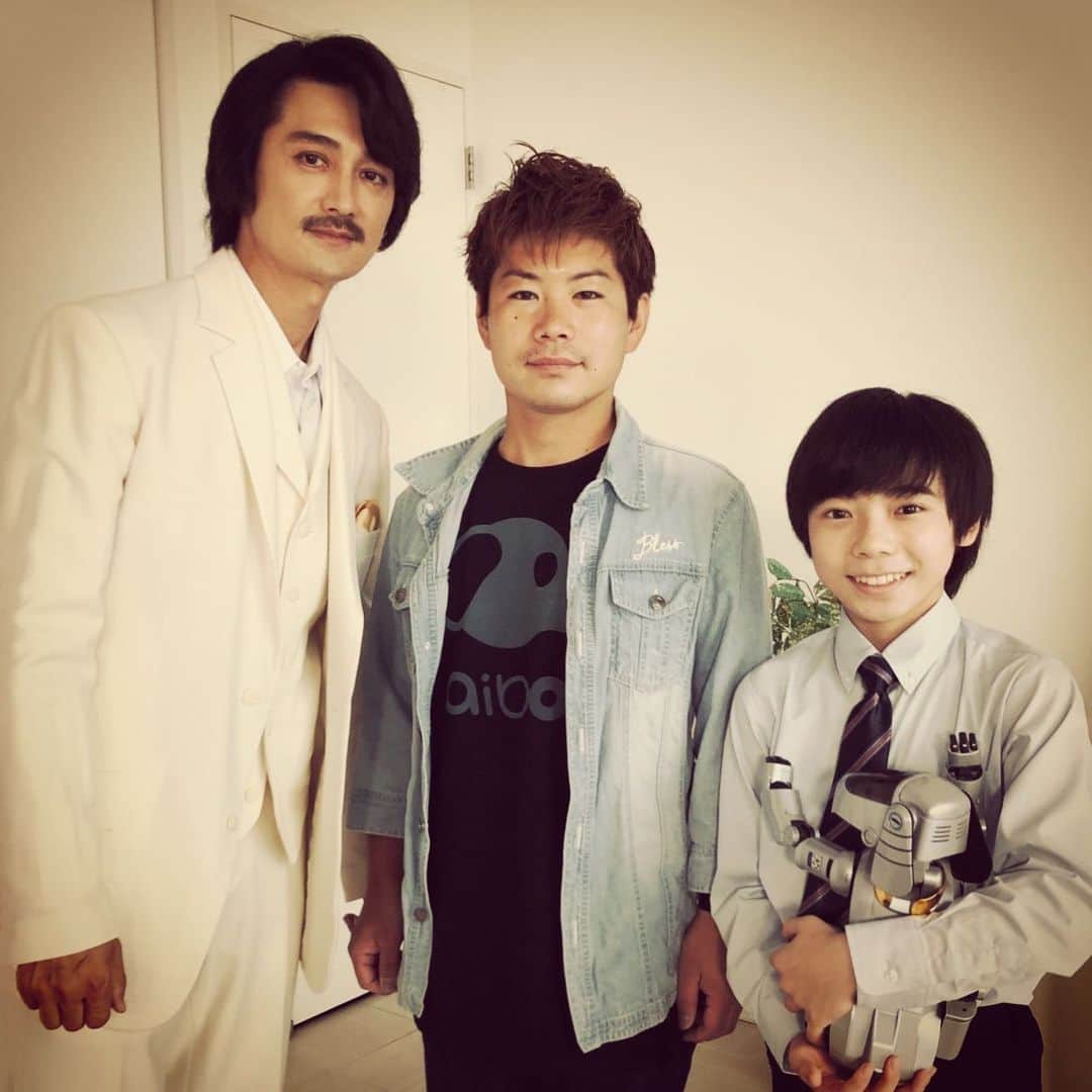 のインスタグラム：「【出演情報：7/12(日) 9:00〜仮面ライダーゼロワン38話】 いや〜ほんの少しですが念願の仮面ライダーに参加できて大変嬉しかったです。欲をいうと「へーんしーﾝヌ！」と昭和Ver.で叫びたかったですが。。。代わりにヘアスタイルをど昭和なヒゲダンス風に仕上げてもらいました。いつの日かおっさんライダーになれたらと念じます。 今回も、もしやもしや！？子供たちに石をぶつけられそうな役どころなのか！？・・・明日の回想シーンをお楽しみに🤙🏿 写真：作野良輔 監督（真ん中）・流星くん（右）+ aibo https://www.tv-asahi.co.jp/zero-one/story/?38  #KamenRiderZeroOne #仮面ライダーゼロワン #aibo #アイボ #Toei #東映 #IshinomoriShotaro #石ノ森章太郎 #superhero #hero #特撮ヒーロー #tvshow #tvseries #ドラマ」